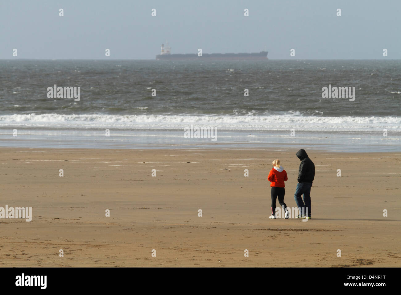 Ein paar gehen im Winter auf Ballybunion Strand, County Kerry, Irland Stockfoto