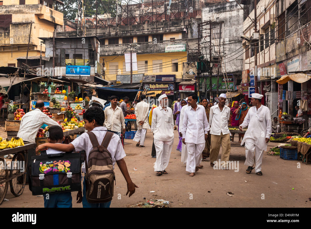 Indische Männer mit Gandhi hüten, zu Fuß durch einen Markt in Varanasi, Indien Stockfoto