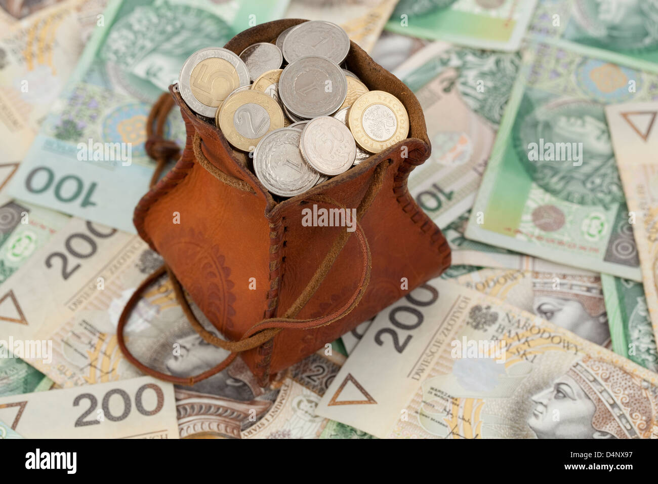 volle Geld-Beutel mit Münzen auf den Banknoten Stockfoto