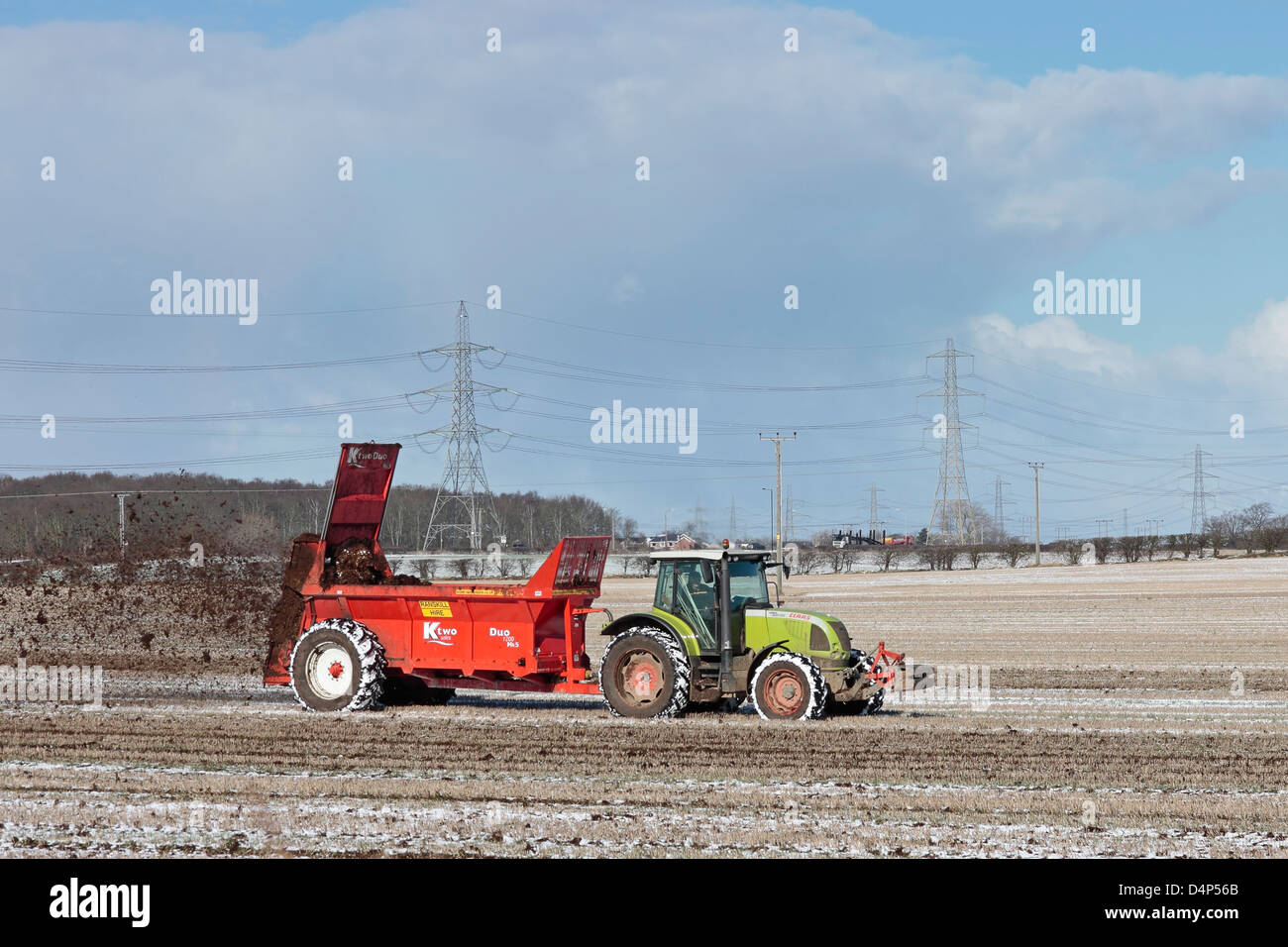 Landwirt Dreck verbreiten ein Feld im Schnee Stockfoto