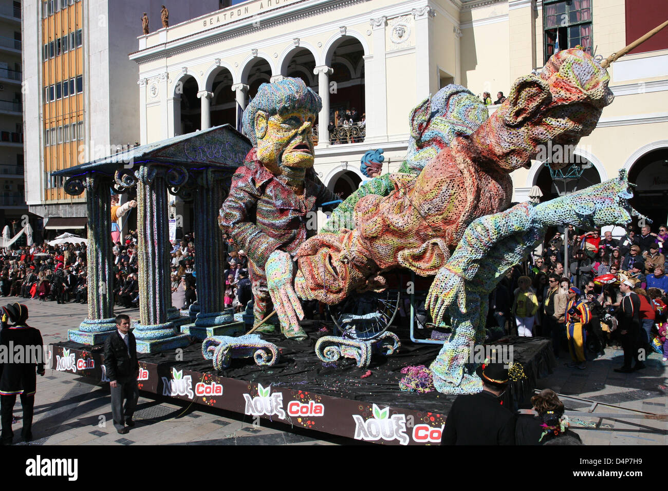 Die deutsche Bundeskanzlerin, Angela Merkel, schiebt Schaeubles Rollstuhl, einen griechischen Kebab mit den Köpfen von Antonis Samaras, Evangelos Venizelos und Kouvelis auf dem Jahrmarkt in Patras Griechenland, 17. März 2013 hält. Der Patras-Karneval ist die größte Veranstaltung ihrer Art in Griechenland und eine der größten in Europa, mit mehr als 160 Jahren Geschichte. Foto: Menelaos Michalatos Stockfoto