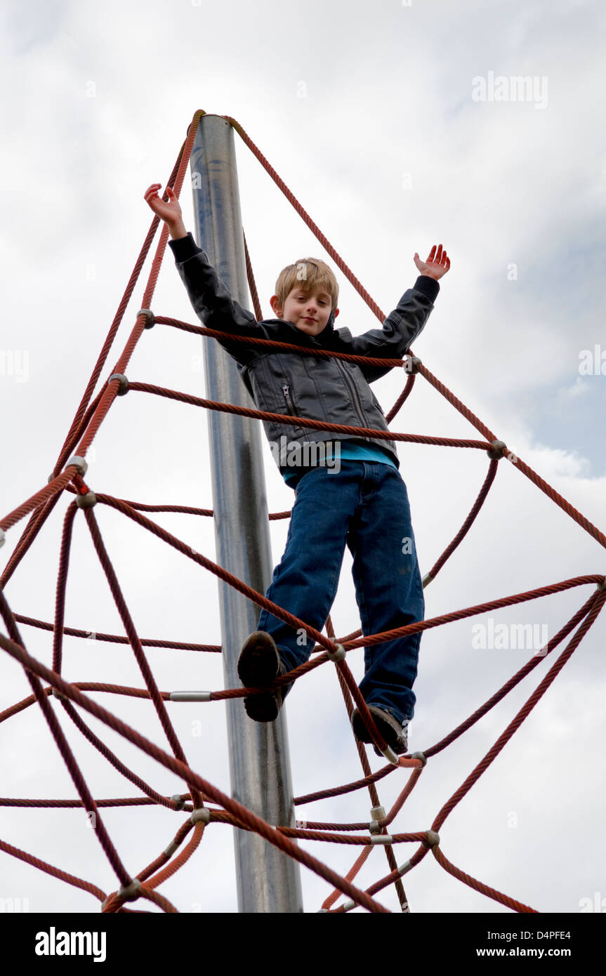 10 Jahre alten kaukasischen jungen an einem Seil Klettergerüst im Park in Bristol, UK Stockfoto