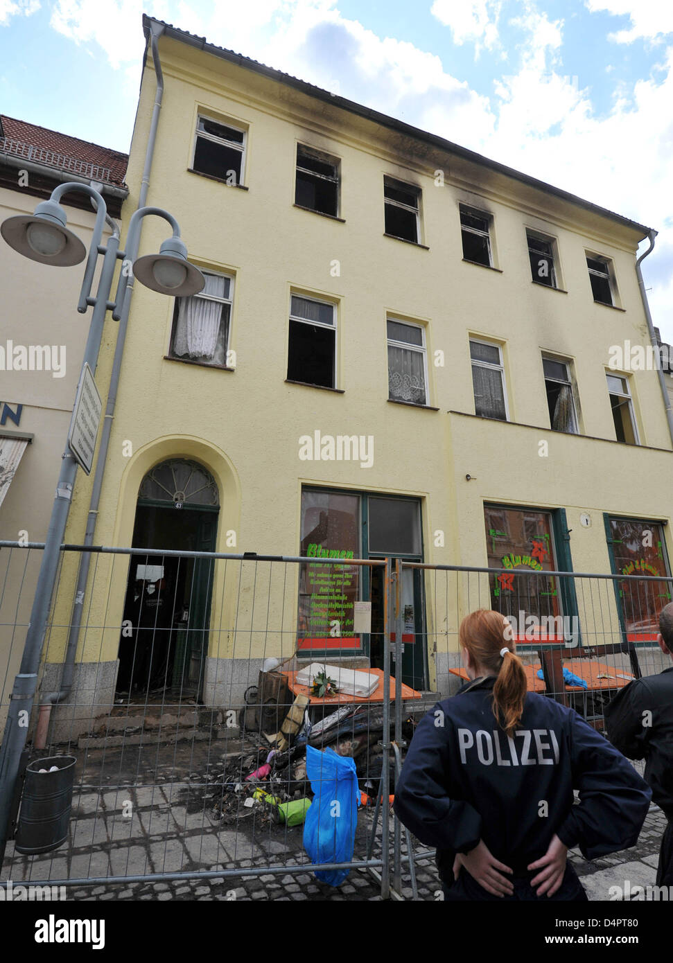 Polizisten sperren die Räumlichkeiten rund um ein Haus in Sangerhausen, Deutschland, 29. August 2009. Zwei Kinder im Alter von vier und neun Jahren starben bei einem Brand in dem Mehrfamilienhaus in der Nacht. Mehrere Einwohner wurden mit vermuteten Rauchfang Gasvergiftung ins Krankenhaus gebracht. Der Grund für das Feuer ist noch unklar, sagte die Polizei.  Foto: Hendrik Schmidt Stockfoto