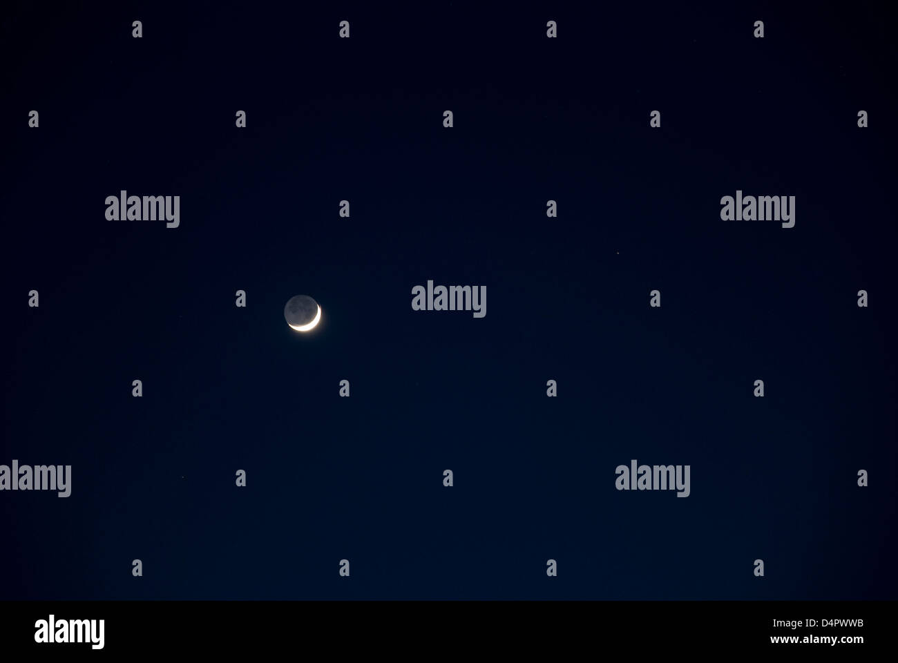 Schönen Neumond über Aarhus V, Dänemark. Des weiteren wird der Mond von Erdschein beleuchtet. Stockfoto