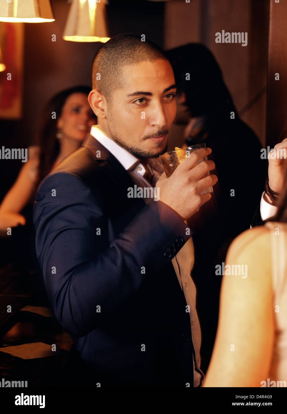 Porträt von einem Mann auf einer Party mit einem Glas Whisky Stockfoto