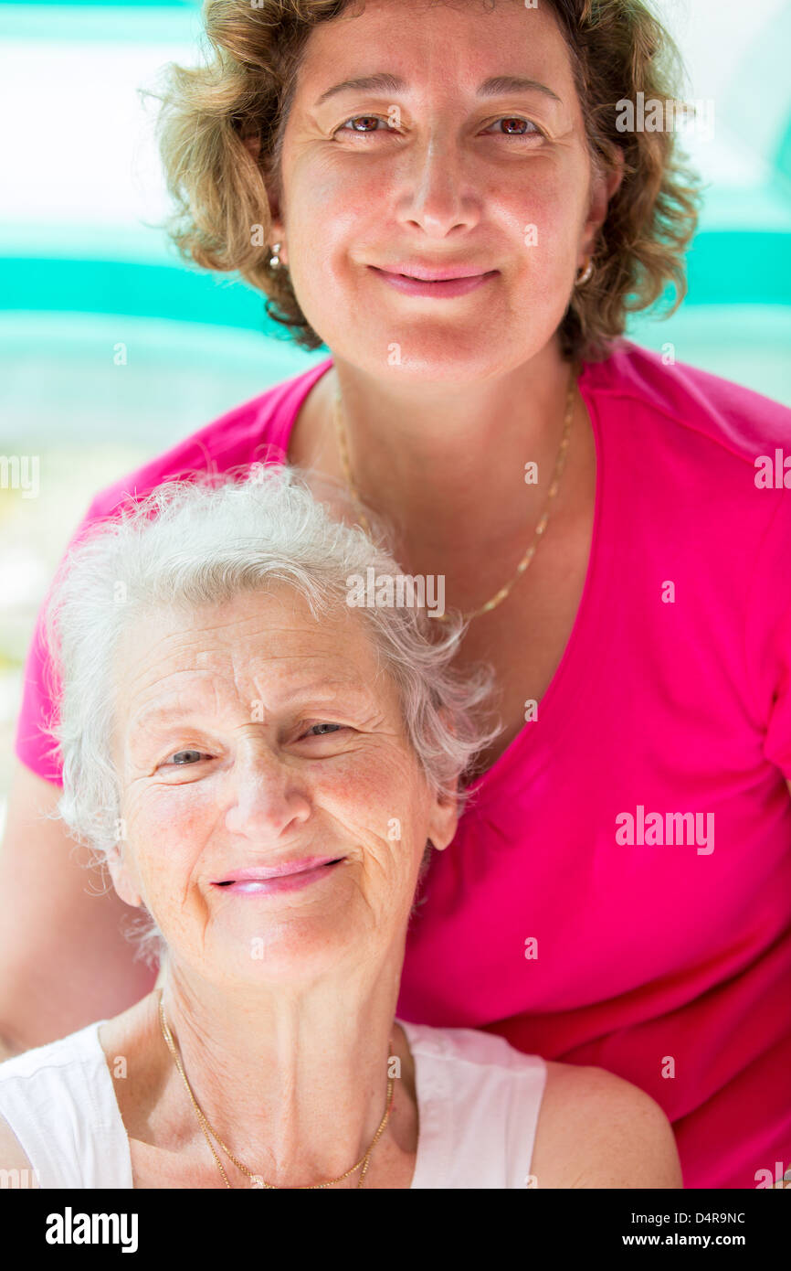 Alte Mutter und ihre Tochter posiert mit zufriedenen Blick. Stockfoto