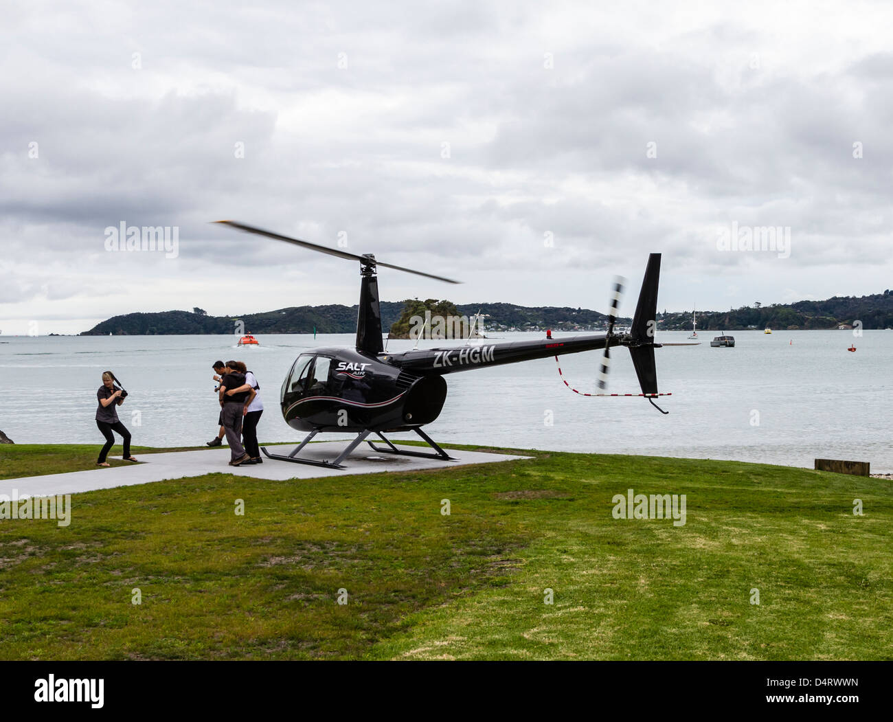 Passagiere, die Einschiffung auf ZK-HGM New Zealand Registrierung schwarze Hubschrauber Robinson R44 Raven II Stockfoto