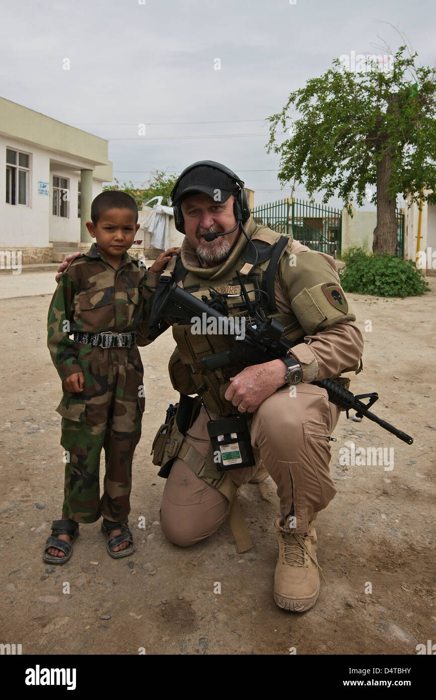 US-Auftragnehmer auf eine Polizeimission in Nordafghanistan posiert für ein Foto mit der afghanischen Polizei Sohn des Häuptlings. Stockfoto