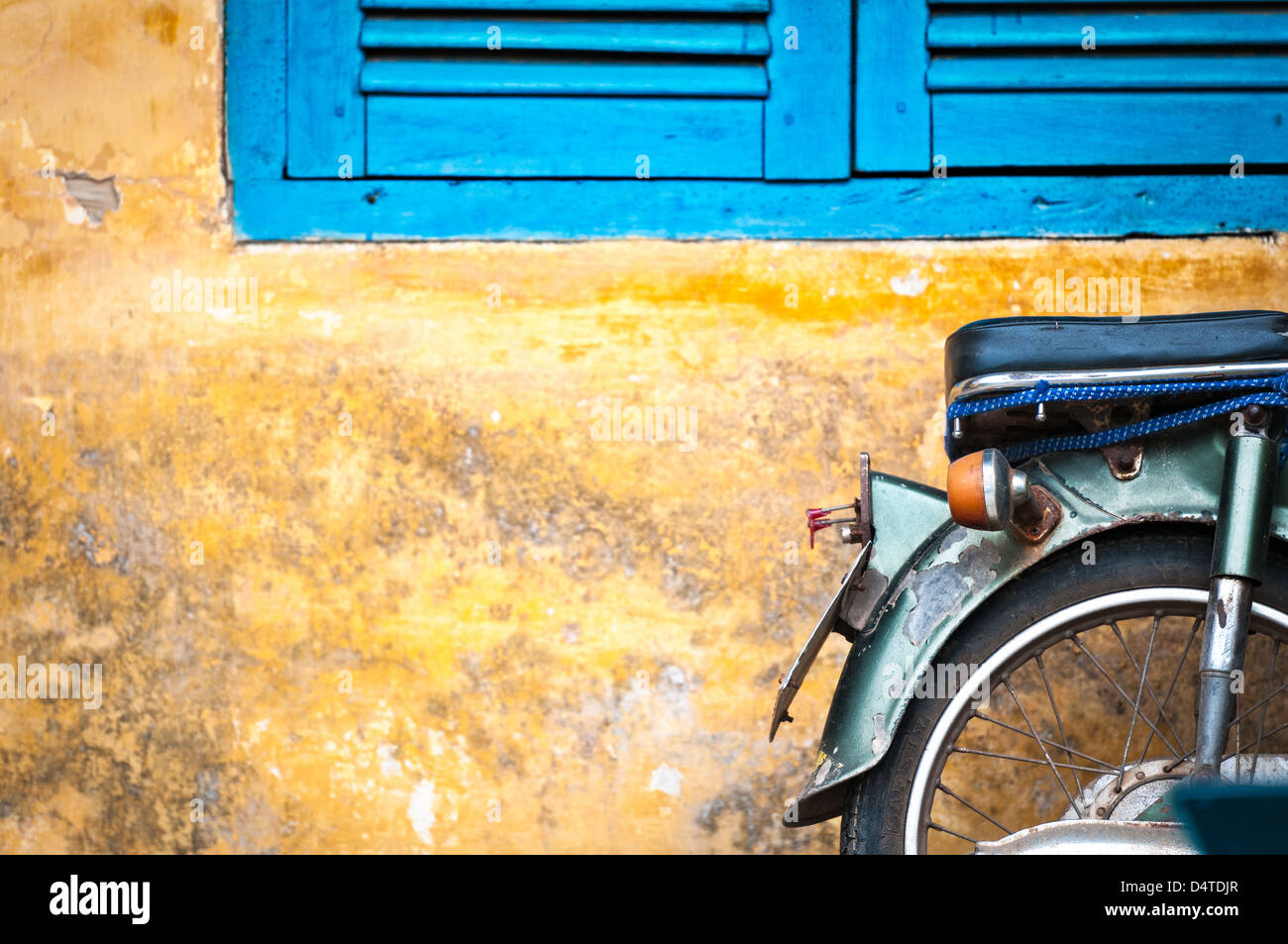 Grüne Roller gegen alte Haus. Verwitterte Wand als Hintergrund. Urban Street in Vietnam, Asien. Moped in verschimmelten geparkt stonewall. M Stockfoto