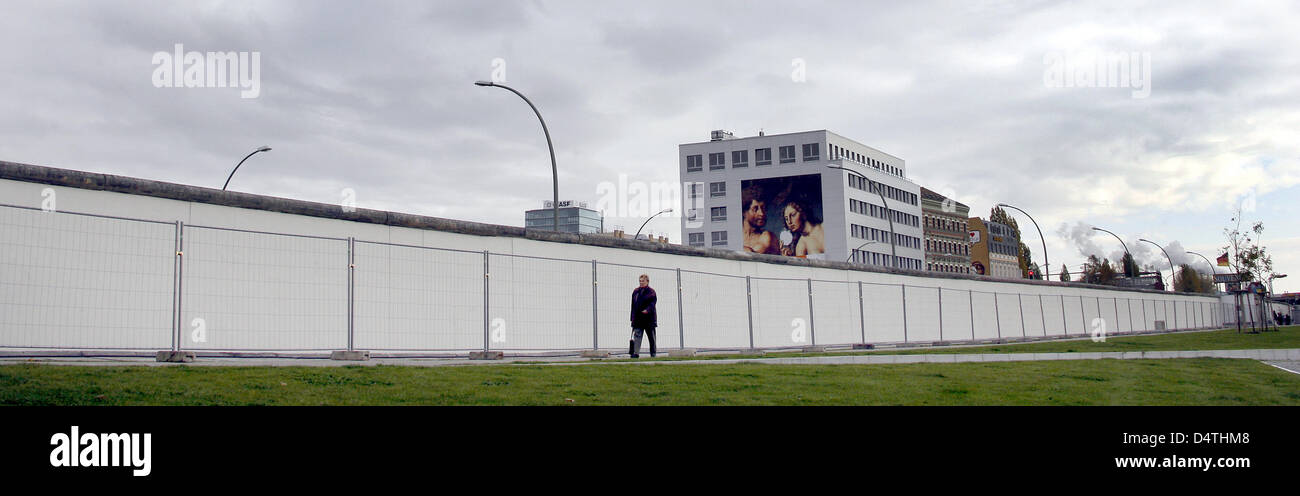 Menschen passieren die East Side Gallery in Berlin, Deutschland, 6. November 2009. Das Gemälde Anzeige Kissingg kommunistischen Führer Leonid Brezhnev und Erich Honecker ist eines der Gemälde von den Künstlern selbst wiederhergestellt werden. Foto: WOLFGANG KUMM Stockfoto