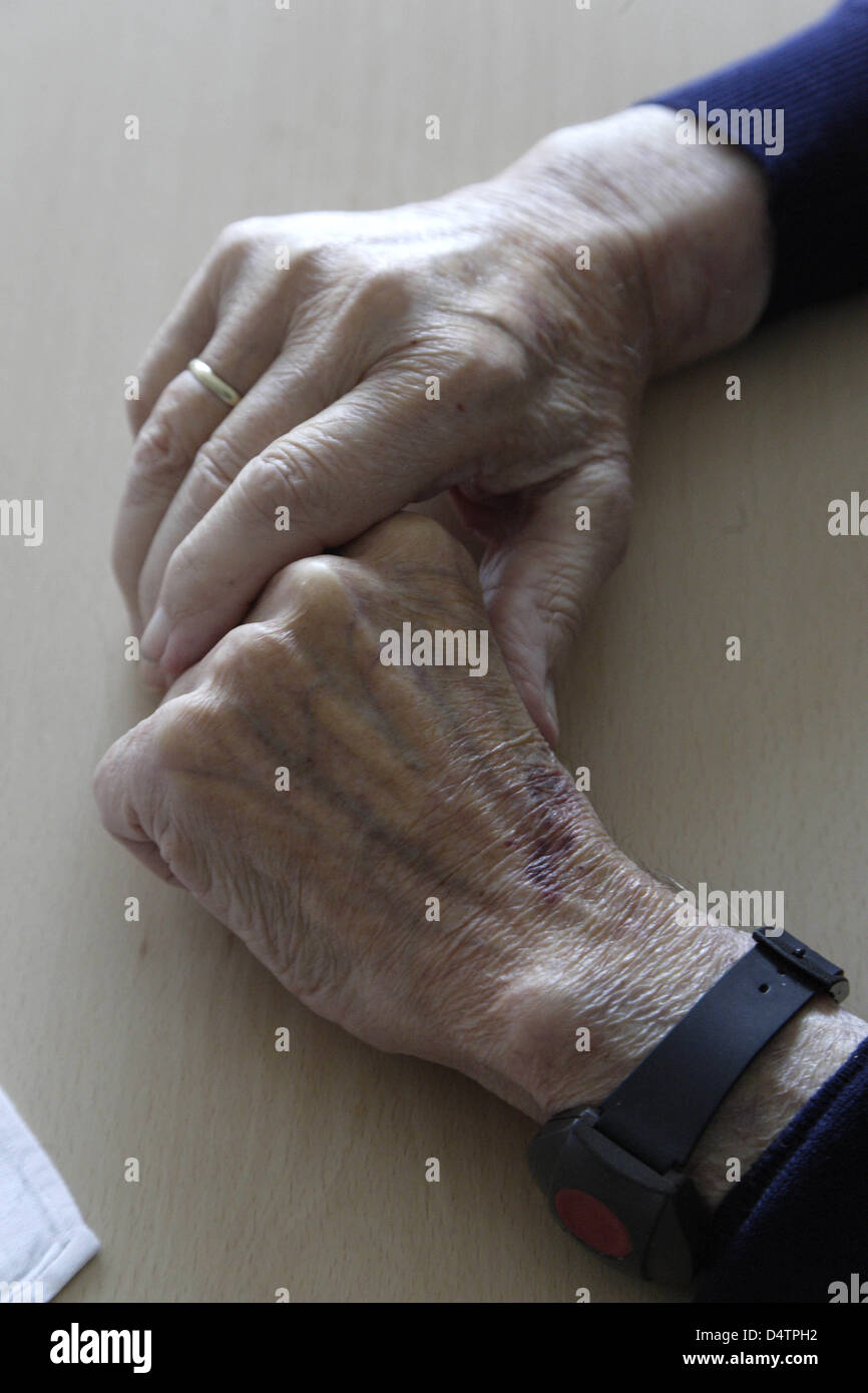 Ein Alter Mann ruht seine Hände auf einem Tisch in einer betreuten Wohngruppe für Patienten mit Demenz in einem Seniorenzentrum in Boppard, Deutschland, 1. Oktober 2009. Foto: Thomas Frey Stockfoto