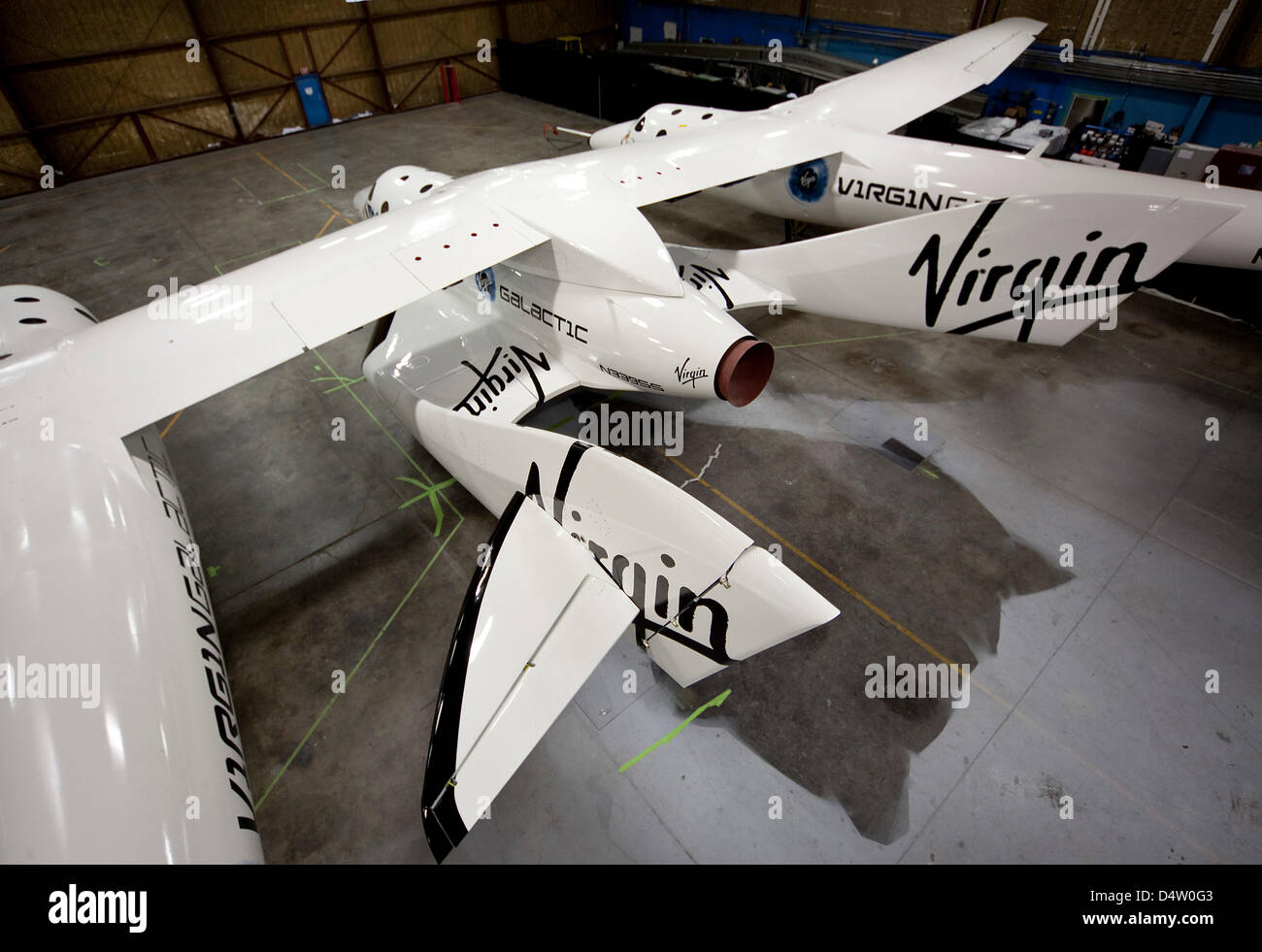 Das Handout Foto vom 7. Dezember 2009 zeigt SpaceShipTwo' (M), angebracht, Träger Flugzeug "WhiteKnightTwo", in einem Hangar in der Mojave-Wüste, Kalifornien, USA. Die offizielle Präsentation des "SpaceShipTwo" wird am gleichen Abend stattfinden. Britische Milliardär Sir Richard Branson will private Raumflüge in naher Zukunft anbieten. Fördermaschine-Flugzeug ist "WhiteKnightTwo" entwickelt t Stockfoto