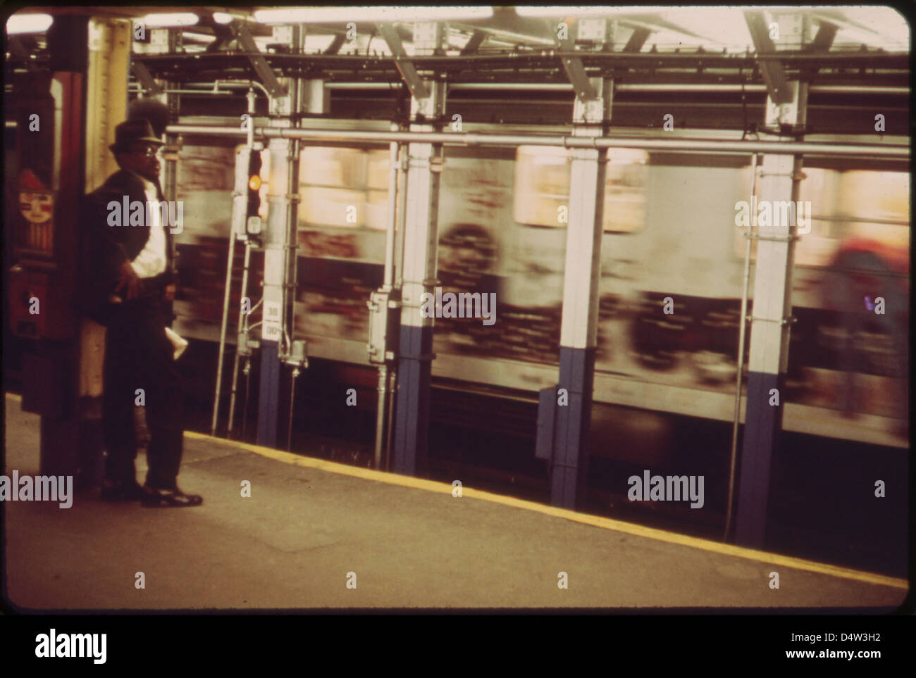 Ein Foto vom Mai 1973, das einen Mann zeigt, der sich vom Brüllen eines sich nähernden U-Bahn-Zuges in New York City zurückzieht. Das Bild erfasst die Intensität und den Alltag des städtischen Nahverkehrs. Stockfoto