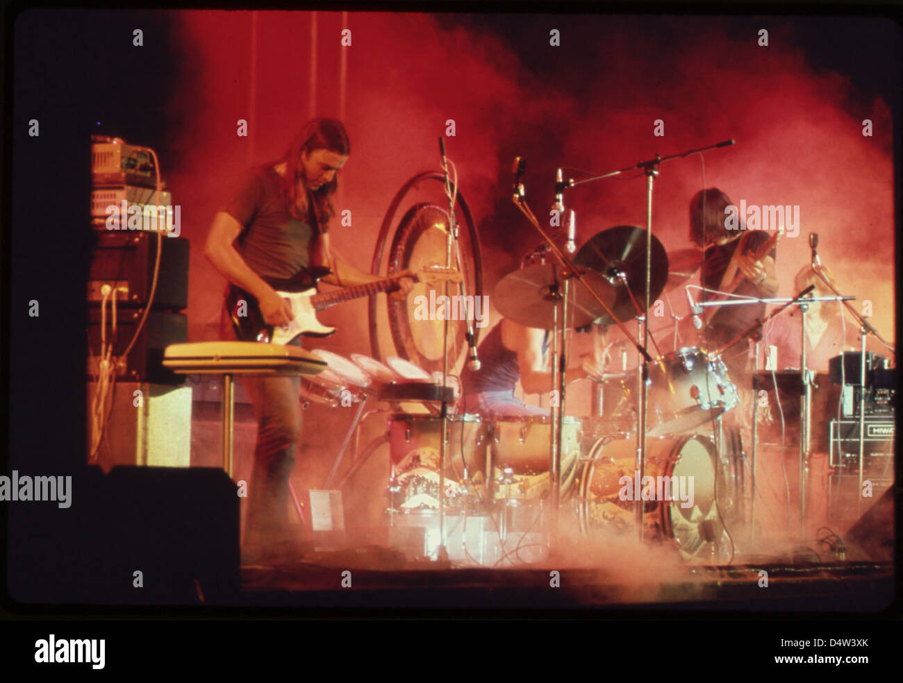 Ein Foto von einem Pink Floyd Konzert im Merriweather Post Pavilion aus dem Jahr 1973 mit den Bandmitgliedern David Gilmour, Nick Mason, Richard Wright und Roger Waters. Das Bild erfasst die stimmungsvolle Atmosphäre, einschließlich roter Lichter und Trockeneiseffekte, als Teil der legendären „Dark Side of the Moon“-Tour. Stockfoto