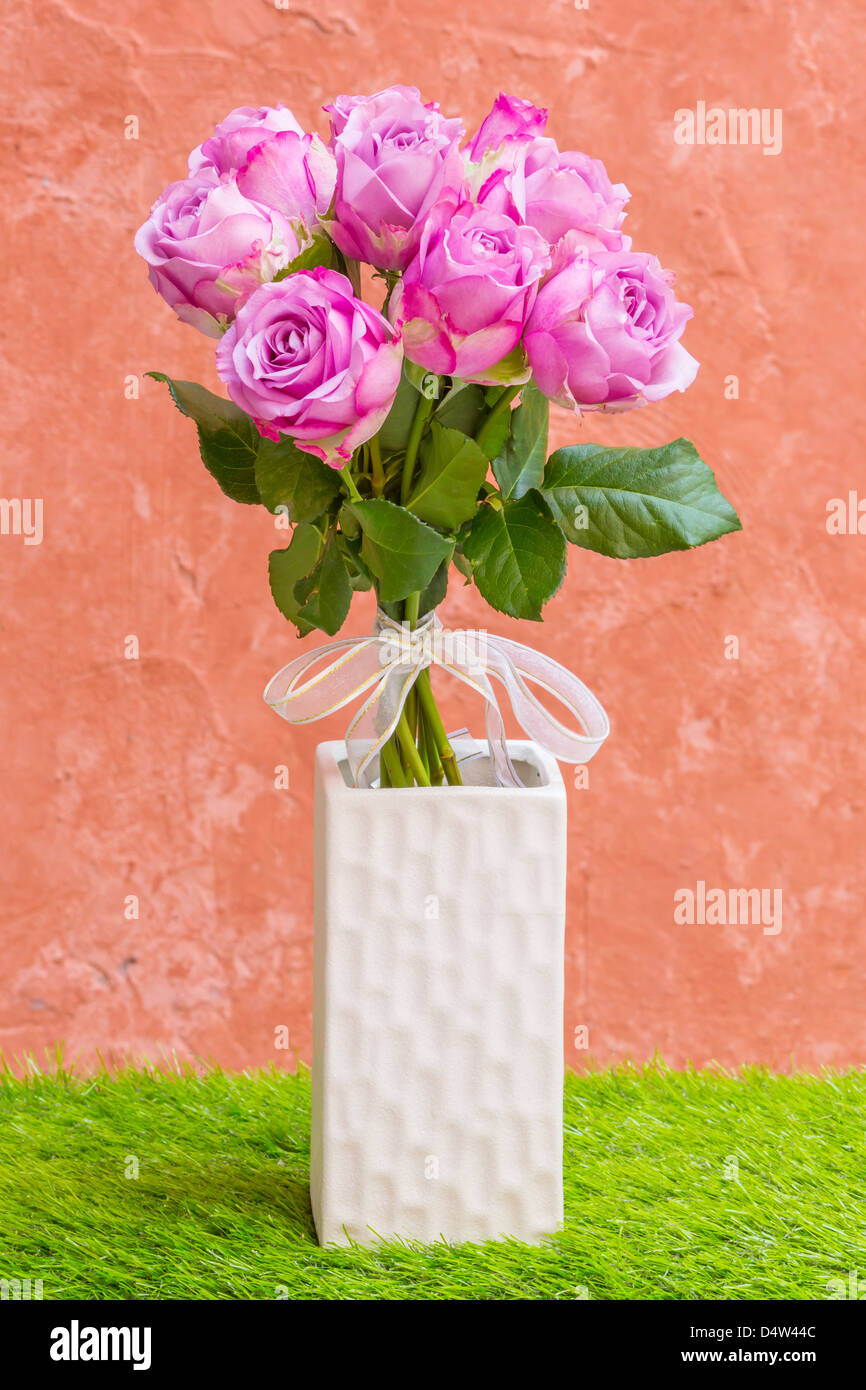 Violette Rose Vase mit weißen Fliege Stockfoto