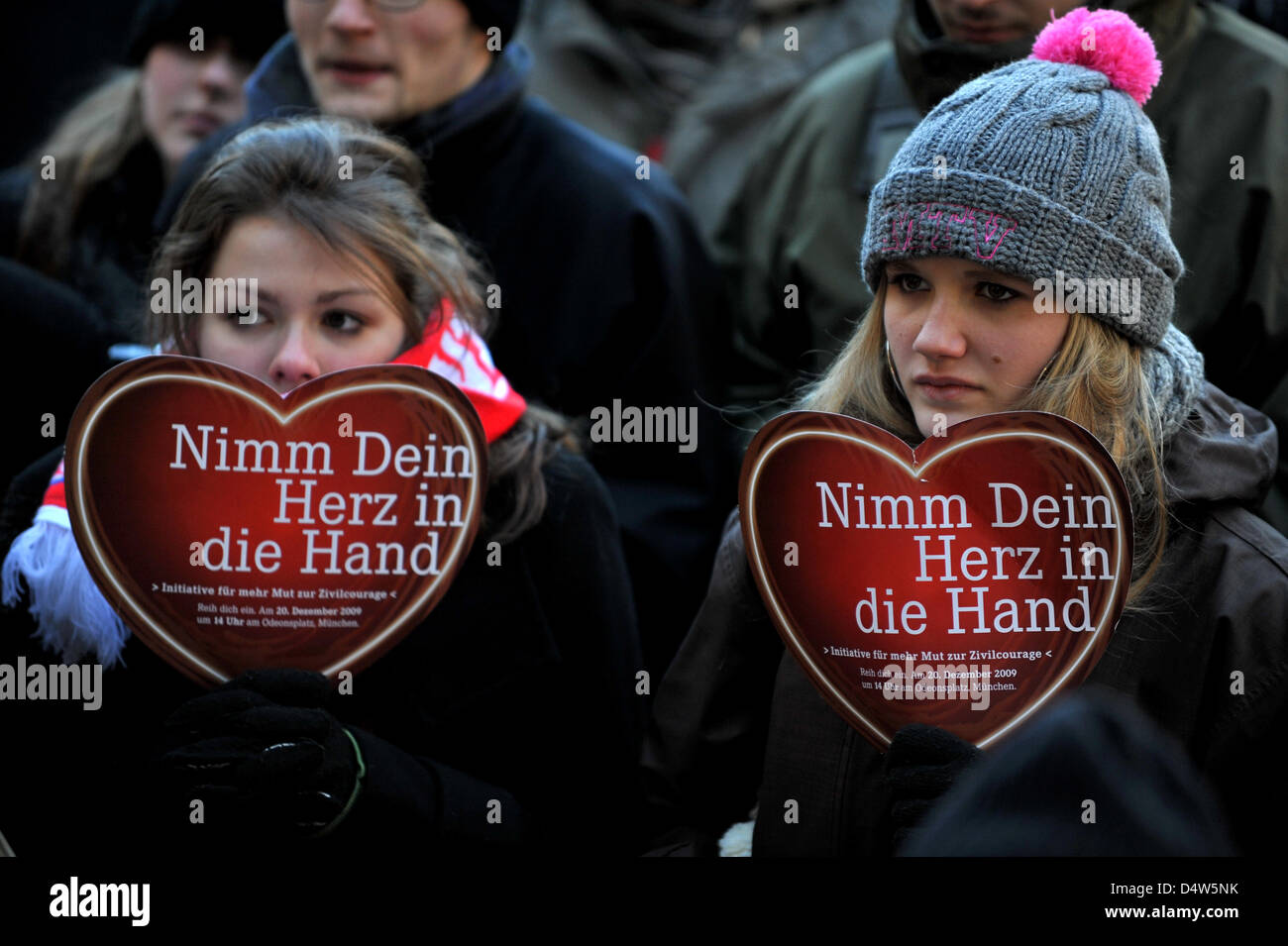 Teilnehmer in einer Manifestation der Dominik-Brunner-Stiftung erhöhen Papiere Lesen des Slogans "Dein Herz in die Hand nehmen" in München, Deutschland, 20. Dezember 2009. Der Slogan fördert Zivilcourage auf dem Hintergrund von Dominik Brunner, der am 12. September von Jugendlichen erschlagen wurde nach der Einnahme von Zivilcourage und vier Kinder schützen wollen. Foto: FRANK LEONHARDT Stockfoto