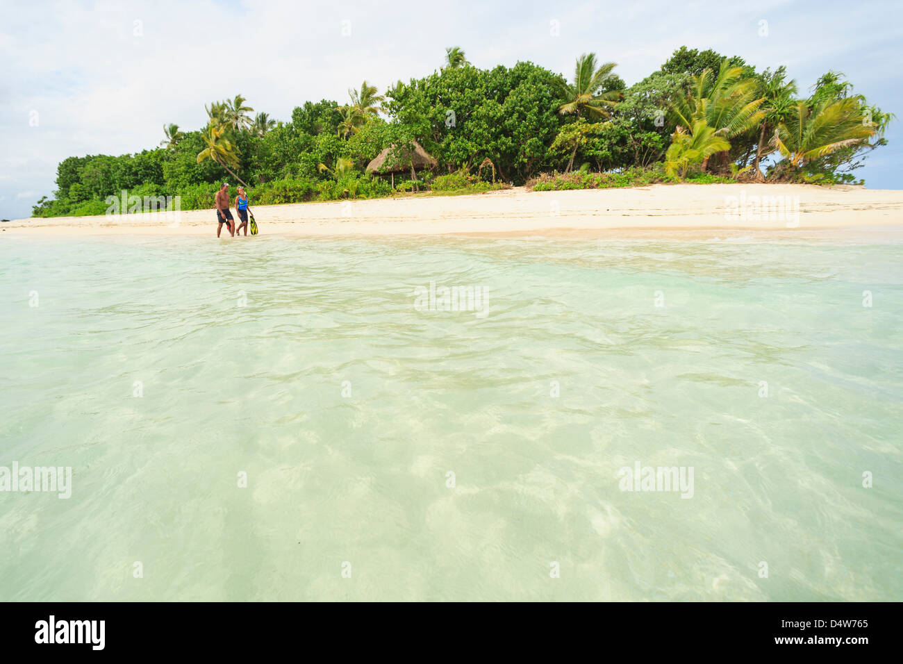 Paare, die am tropischen Strand Stockfoto