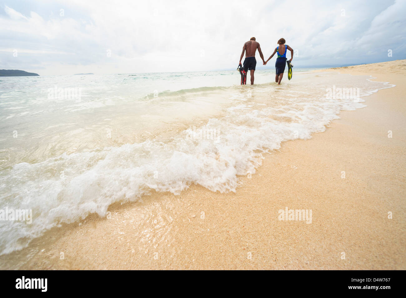 Paare, die am tropischen Strand Stockfoto