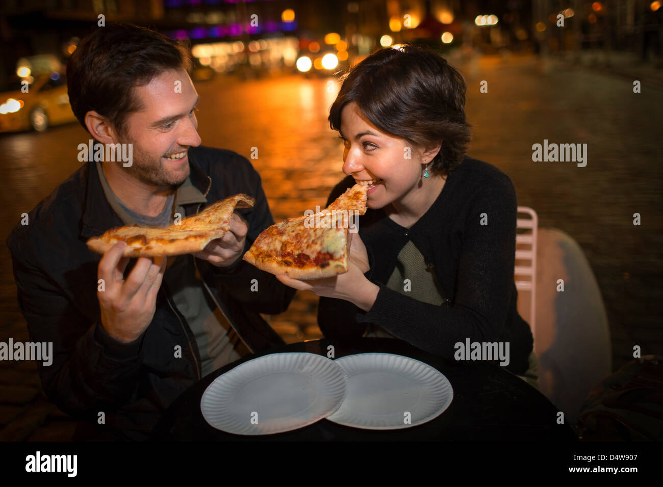 Paar Essen Pizza auf Stadtstraße Stockfoto