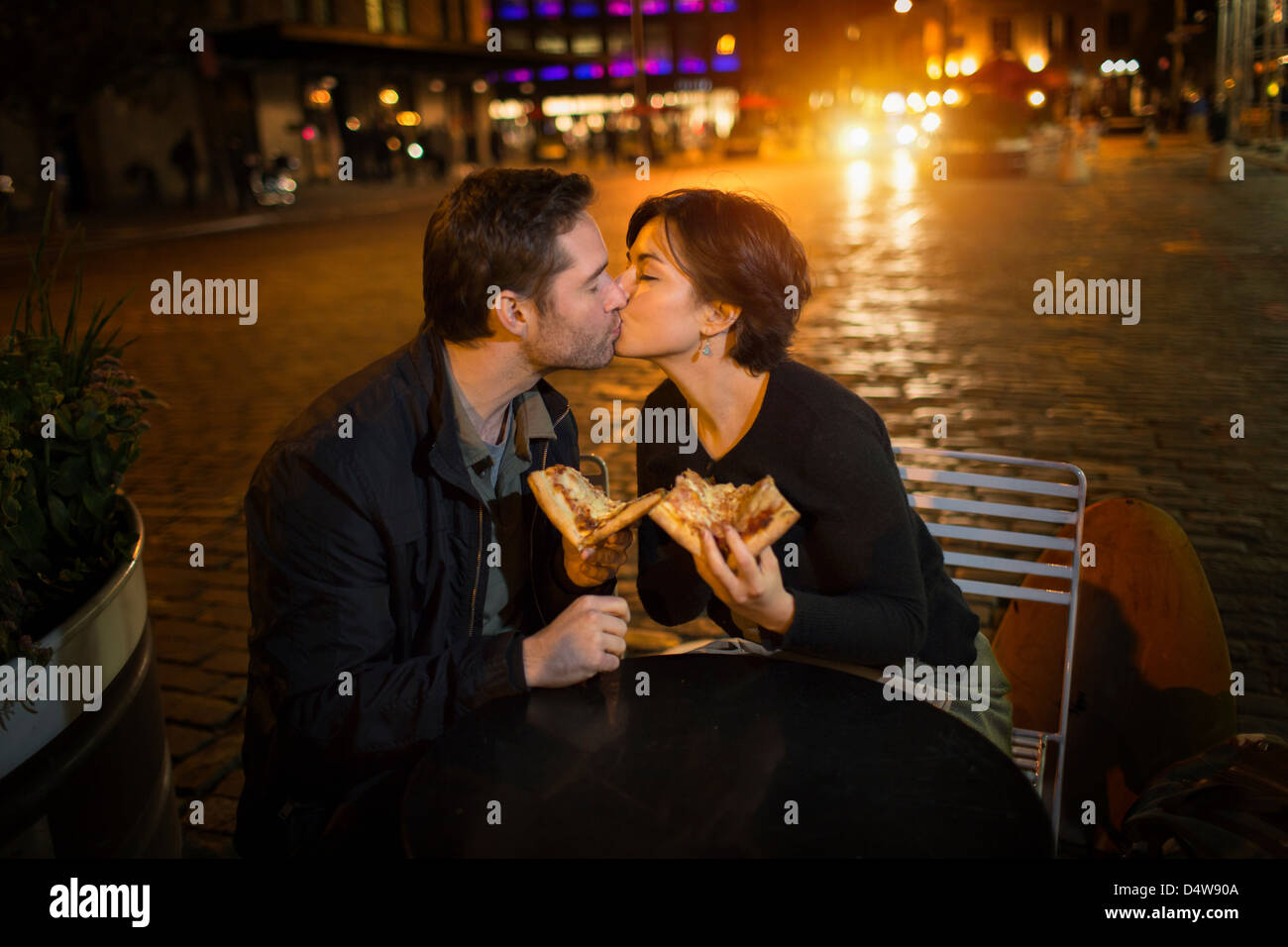 Küssende Paare, die Pizza im freien Stockfoto