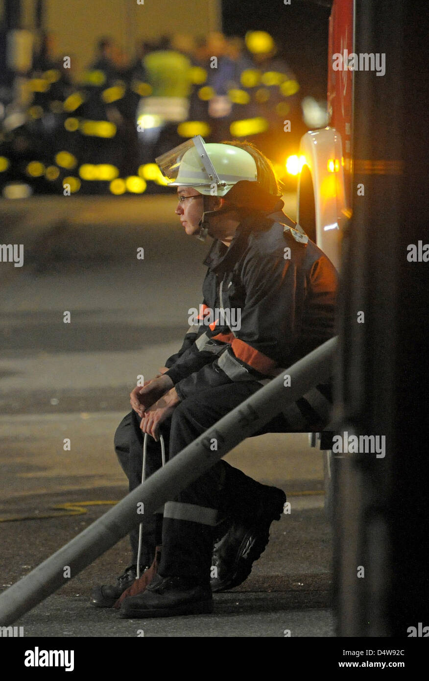 Ein erschöpft Feuerwehrmann auf dem Gelände von einem Amoklauf in Lörrach, Deutschland, 19. September 2010. Eine Frau getötet ihrem ehemaligen Partner und ihre fünf-jährigen Sohn mit Sprengstoff in ihrer Wohnung vor dem Eintritt in ein nahegelegenes Krankenhaus, wo sie erschossen und einen Mitarbeiter getötet und mehrere andere verletzt. Sie war dann erschossen und von Polizisten getötet. Foto: Ronald Wittek Stockfoto