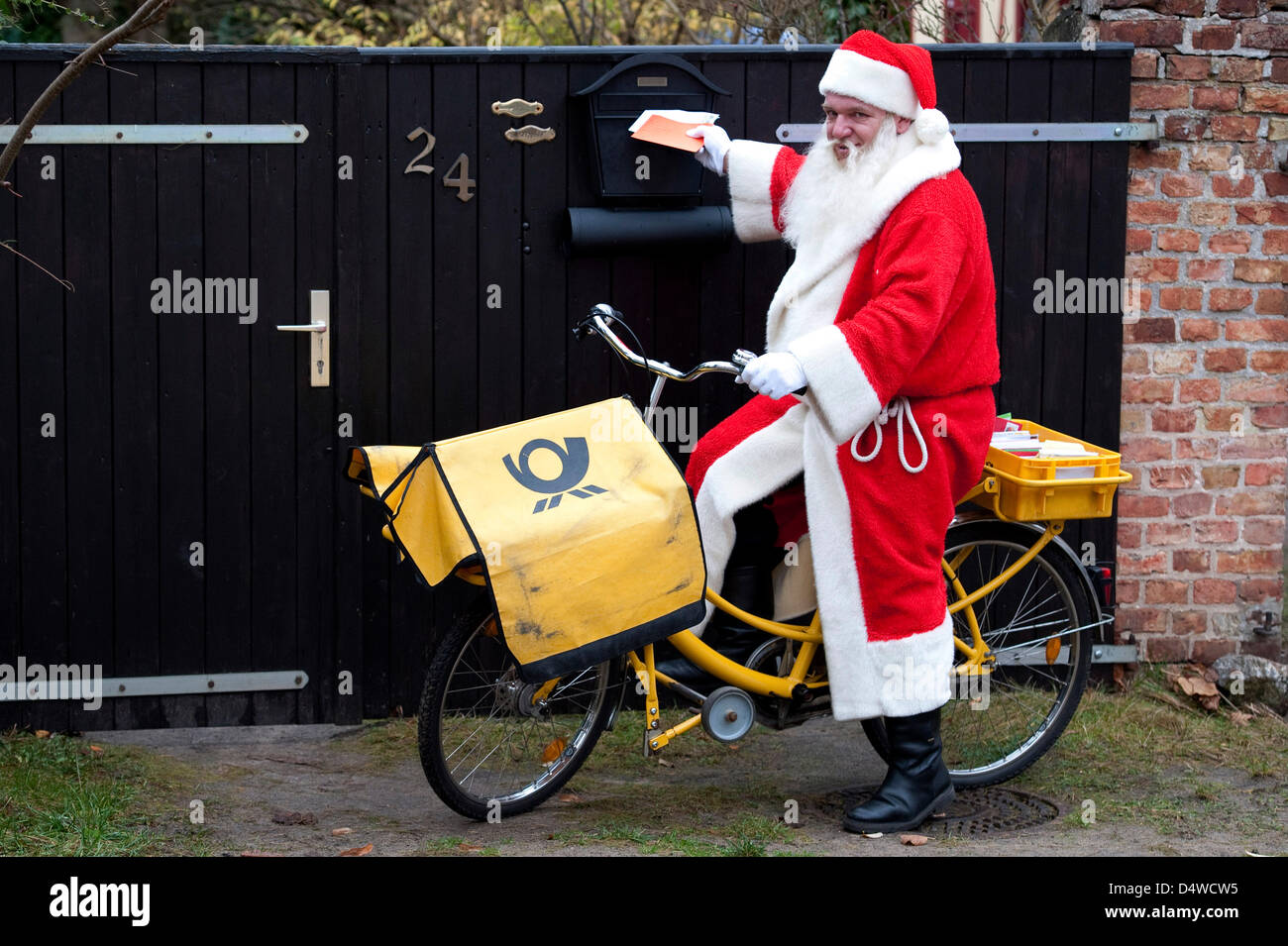 Ein Postbote ein Weihnachtsmann Kostüm reitet auf einem Fahrrad in