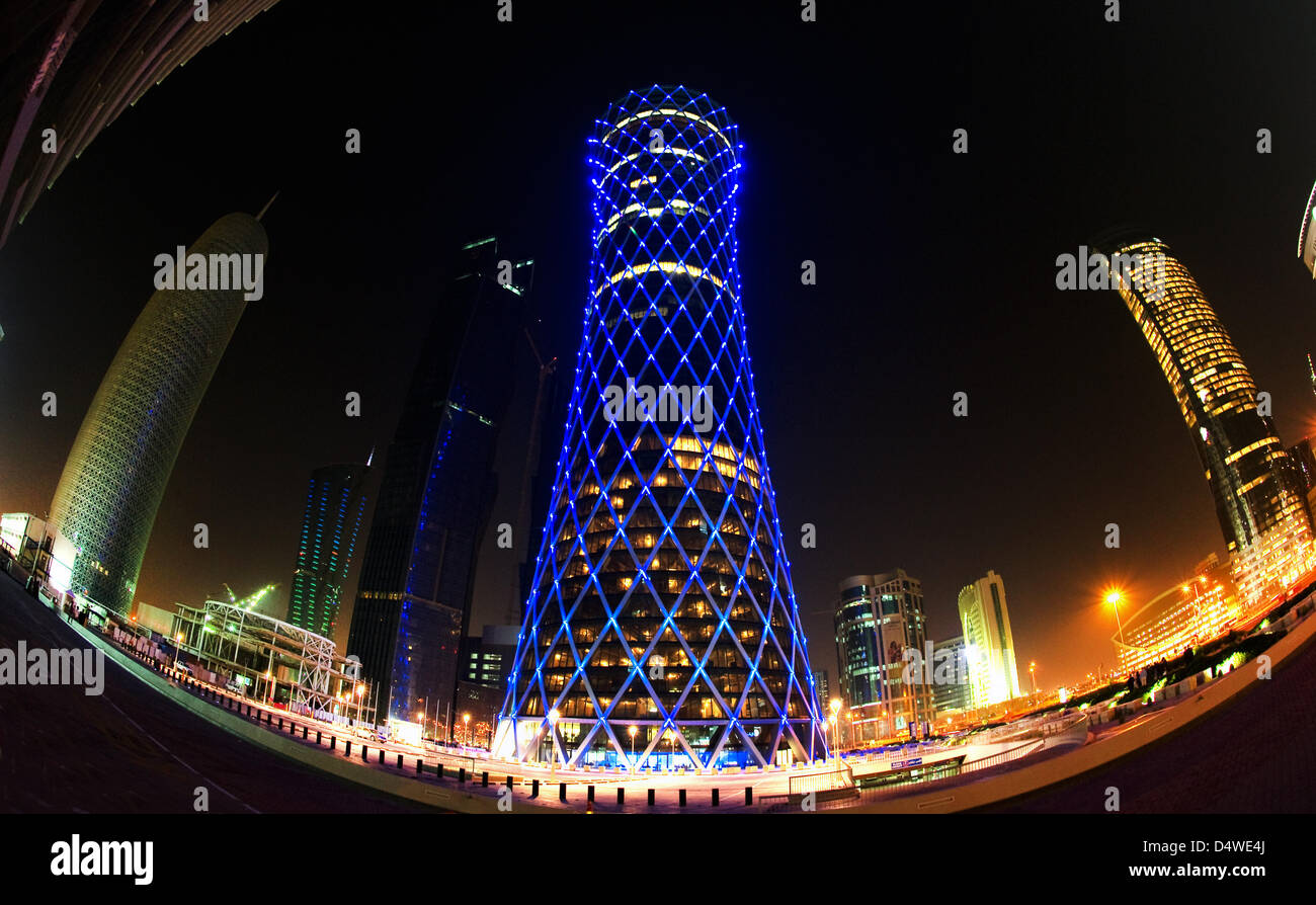 Mittwoch (24.11.2010) bin in Blauem Licht Erstrahlt der "Qipco Turm" in Doha, Katar, Zwischen Weiteren Hochhäusern (Fisheye-Aufnahme). Der Rund 200 Meter hohen Büroturm Im Neuen Hochhausviertel eine der Westbay von Doha Wird Mit Hilfe Eines Beleuchtungskonzeptes, Bei Dem Einzelne, Steuerbare LED-Leuchten Auf Den Knotenpunkten der Gitterstruktur der Außenfassade Angebracht Sind, Sicherheitsbeleuchtung Stockfoto