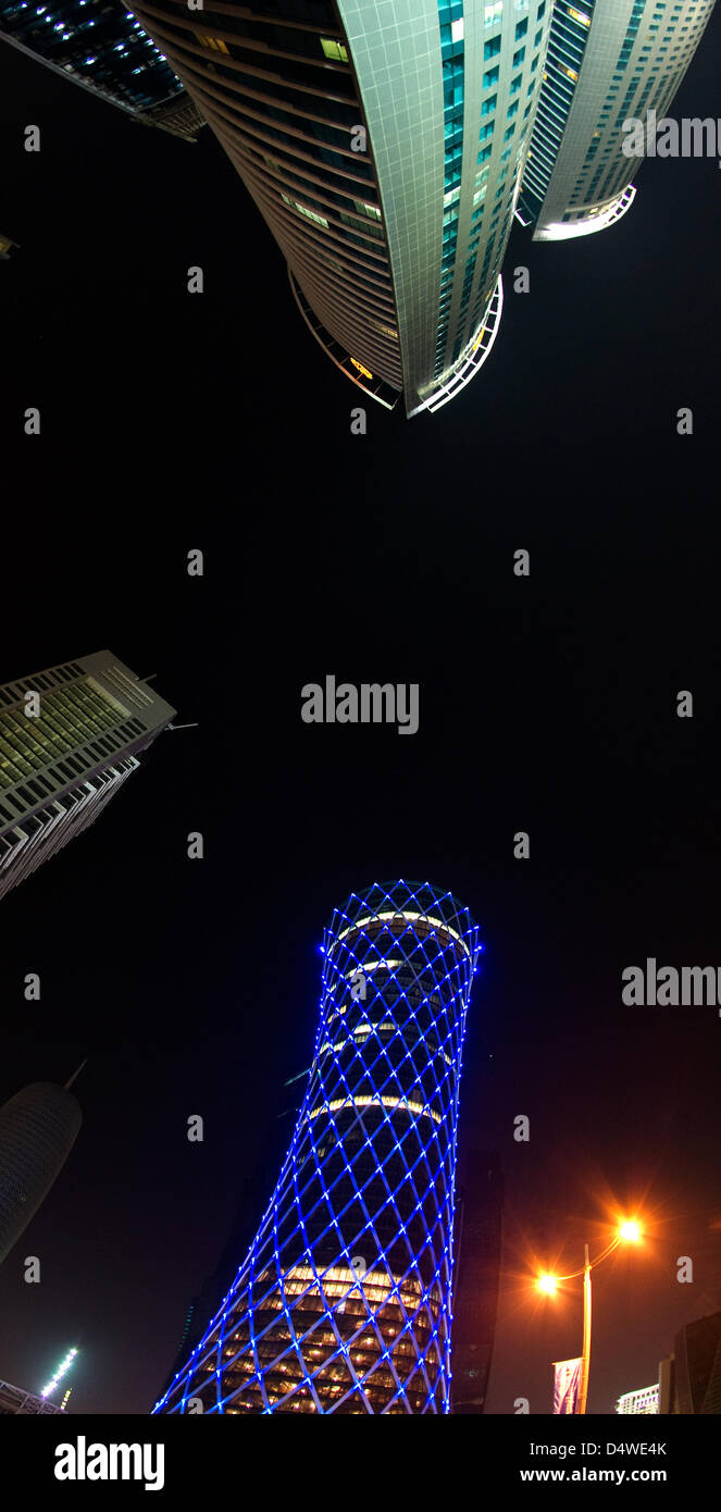 Mittwoch (24.11.2010) bin in Blauem Licht Erstrahlt der "Qipco Turm" in Doha, Katar, Zwischen Weiteren Hochhäusern (Fisheye-Aufnahme). Der Rund 200 Meter hohen Büroturm Im Neuen Hochhausviertel eine der Westbay von Doha Wird Mit Hilfe Eines Beleuchtungskonzeptes, Bei Dem Einzelne, Steuerbare LED-Leuchten Auf Den Knotenpunkten der Gitterstruktur der Außenfassade Angebracht Sind, Sicherheitsbeleuchtung Stockfoto