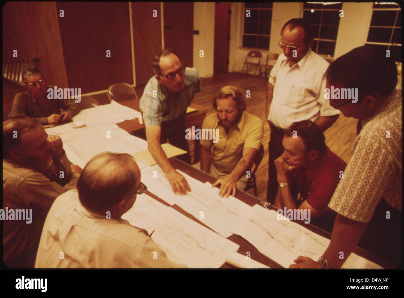 Im Oktober 1972 diskutierte ein Treffen im Rathaus in Rifle, Colorado, über die vorgeschlagenen Routen für den I-70 Highway. Ein Stadtplaner stellt die vor- und Nachteile des Projekts vor, an dem sowohl Vertreter der Gemeinden als auch der Regierungen beteiligt sind. Stockfoto