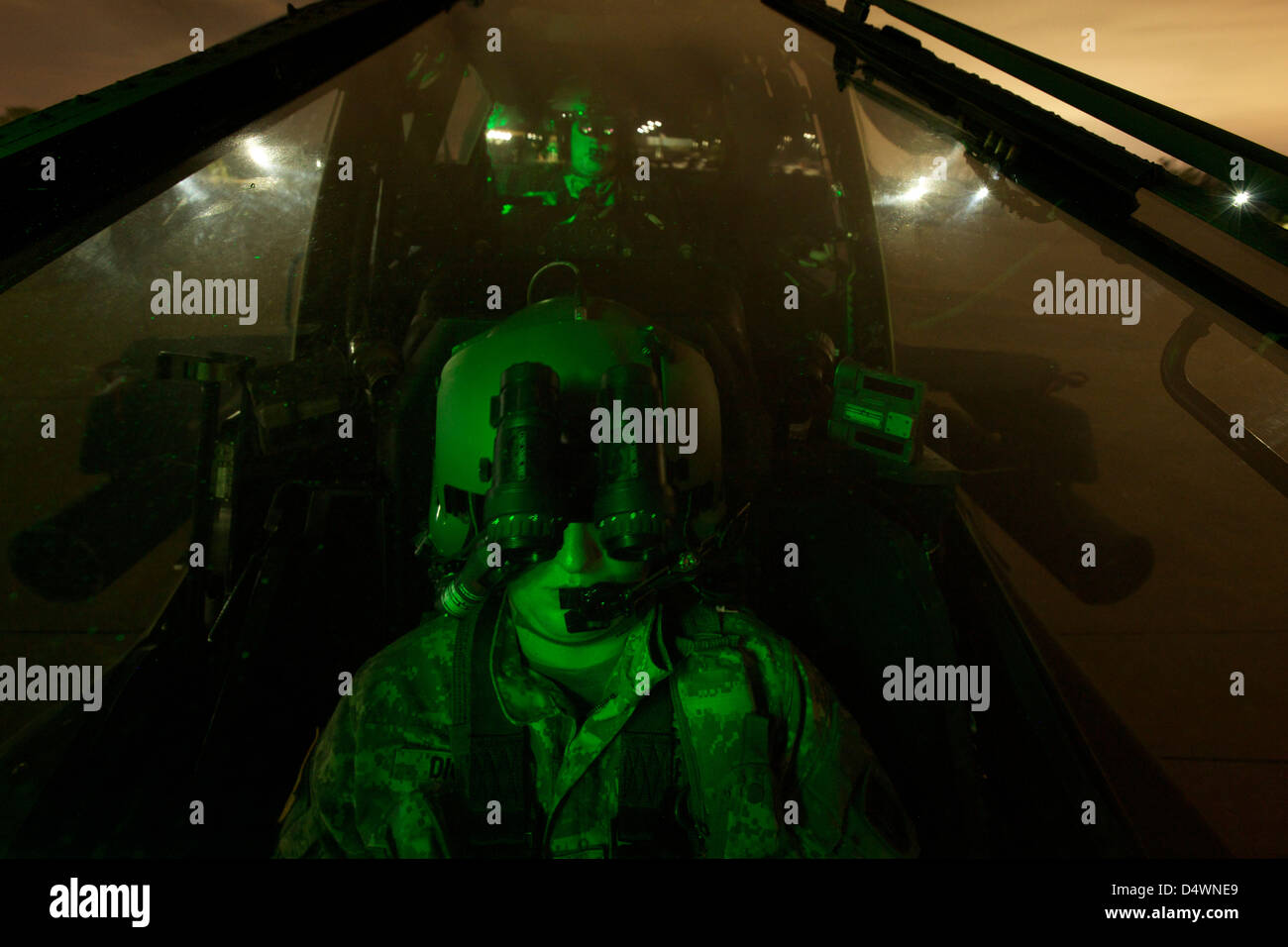 Eine Pilot ausgestattet mit Nachtsicht Brille im Cockpit eines AH-64 Apache Hubschrauber. Stockfoto