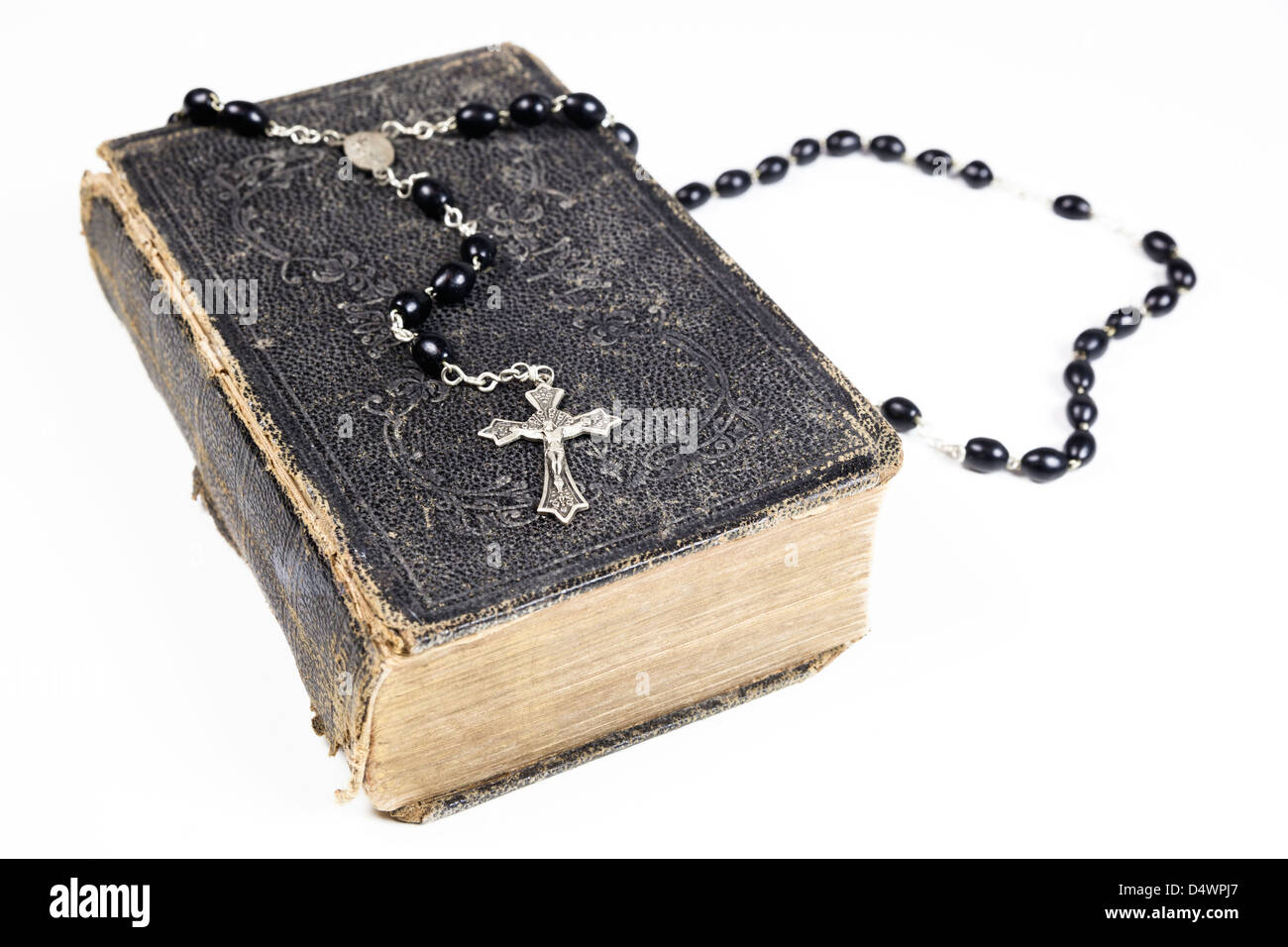Rosenkranz und Kreuz liegend auf einer geöffneten Seite der Bibel isoliert auf einem weißen Hintergrund. Stockfoto