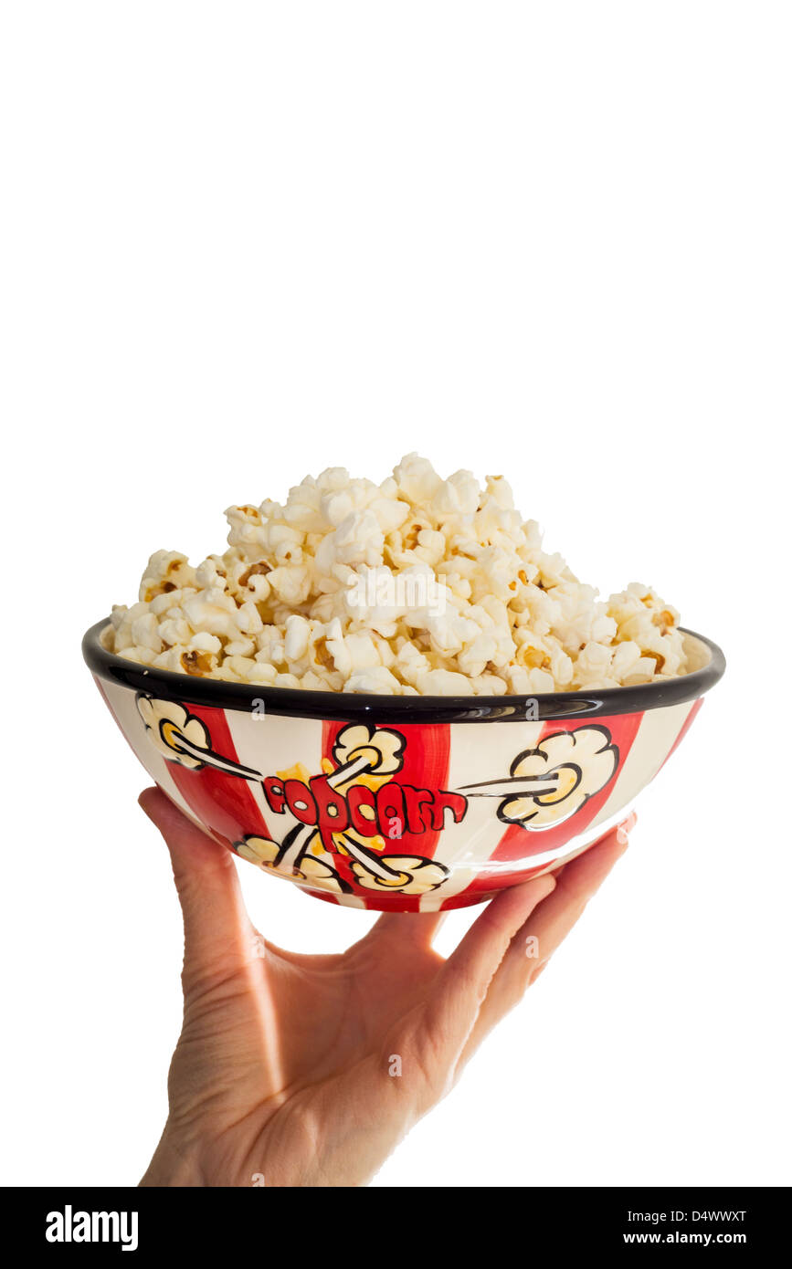 Hand, die Schüssel Popcorn auf weißem Hintergrund Stockfoto