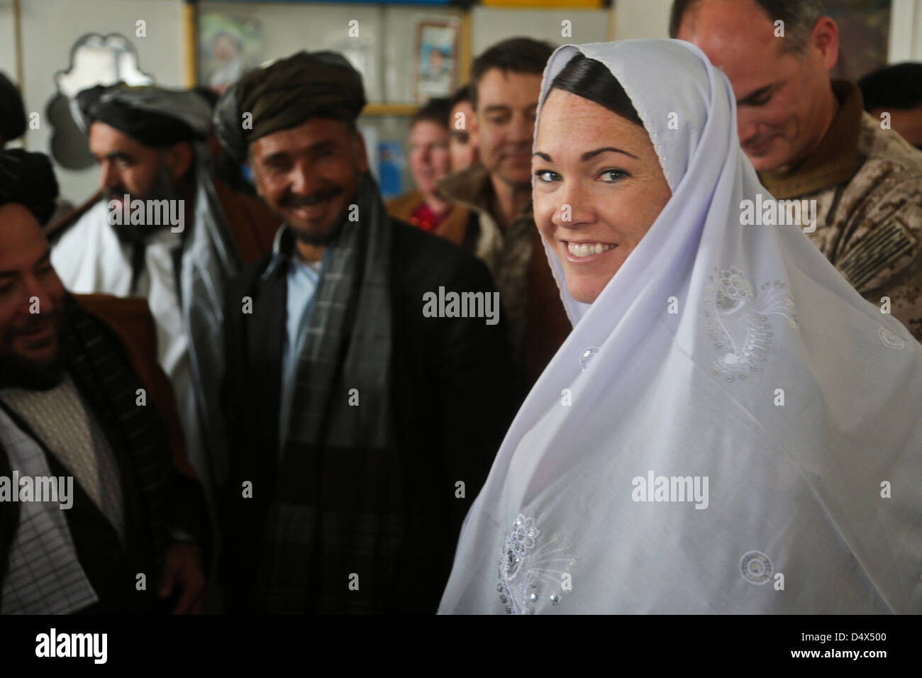 US-Armee Sgt. Jessi Ann McCormick lächelt nach der Übernahme eines Schleiers als Geschenk während einer Schura mit afghanischen Stammesführer und Regierungsvertretern 16. März 2013 in Siya Boghal Dorf, Khas Uruzgan, Afghanistan, Stockfoto