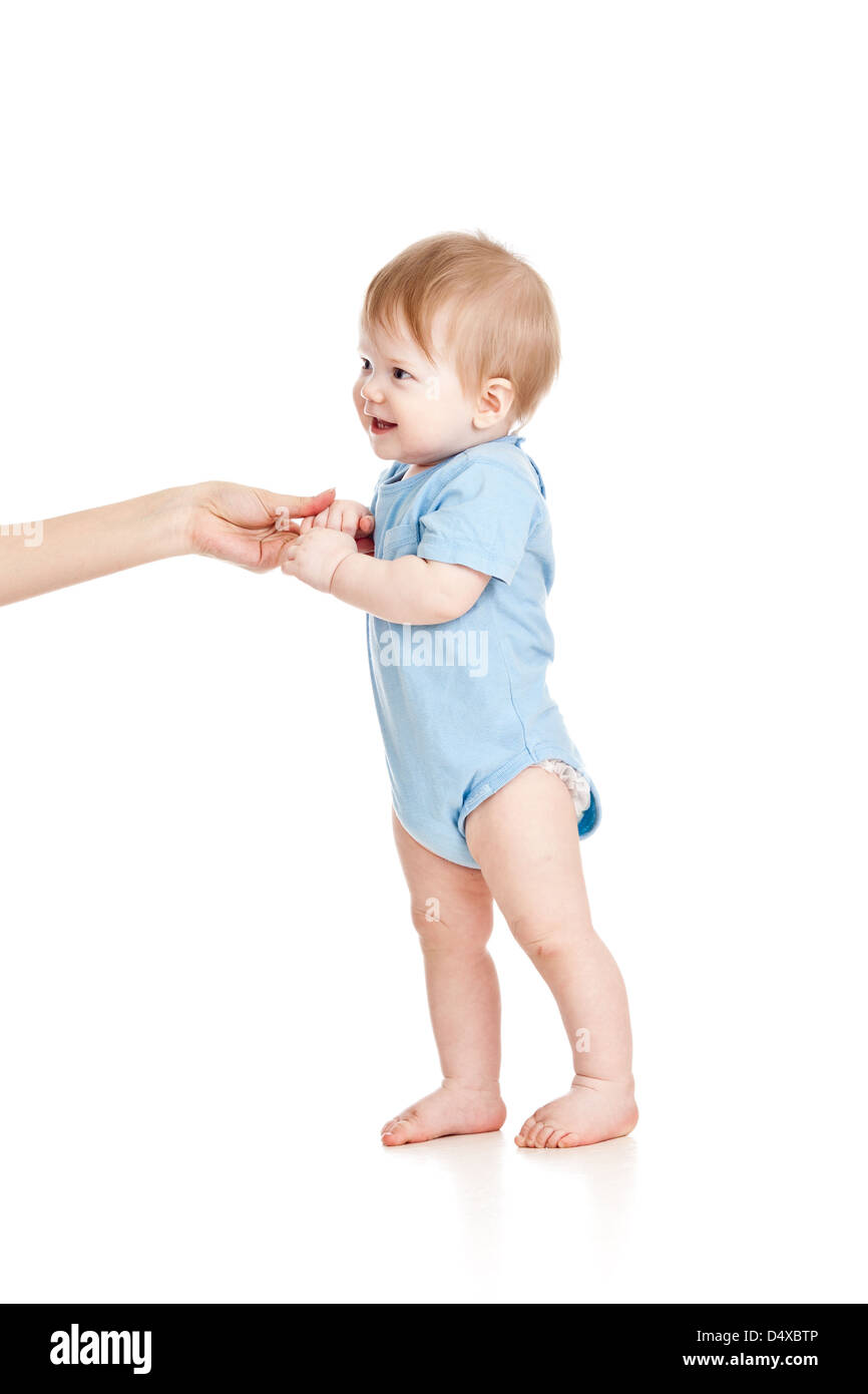 Erste Schritte des Babys mit Hilfe der Mütter Hände Stockfoto