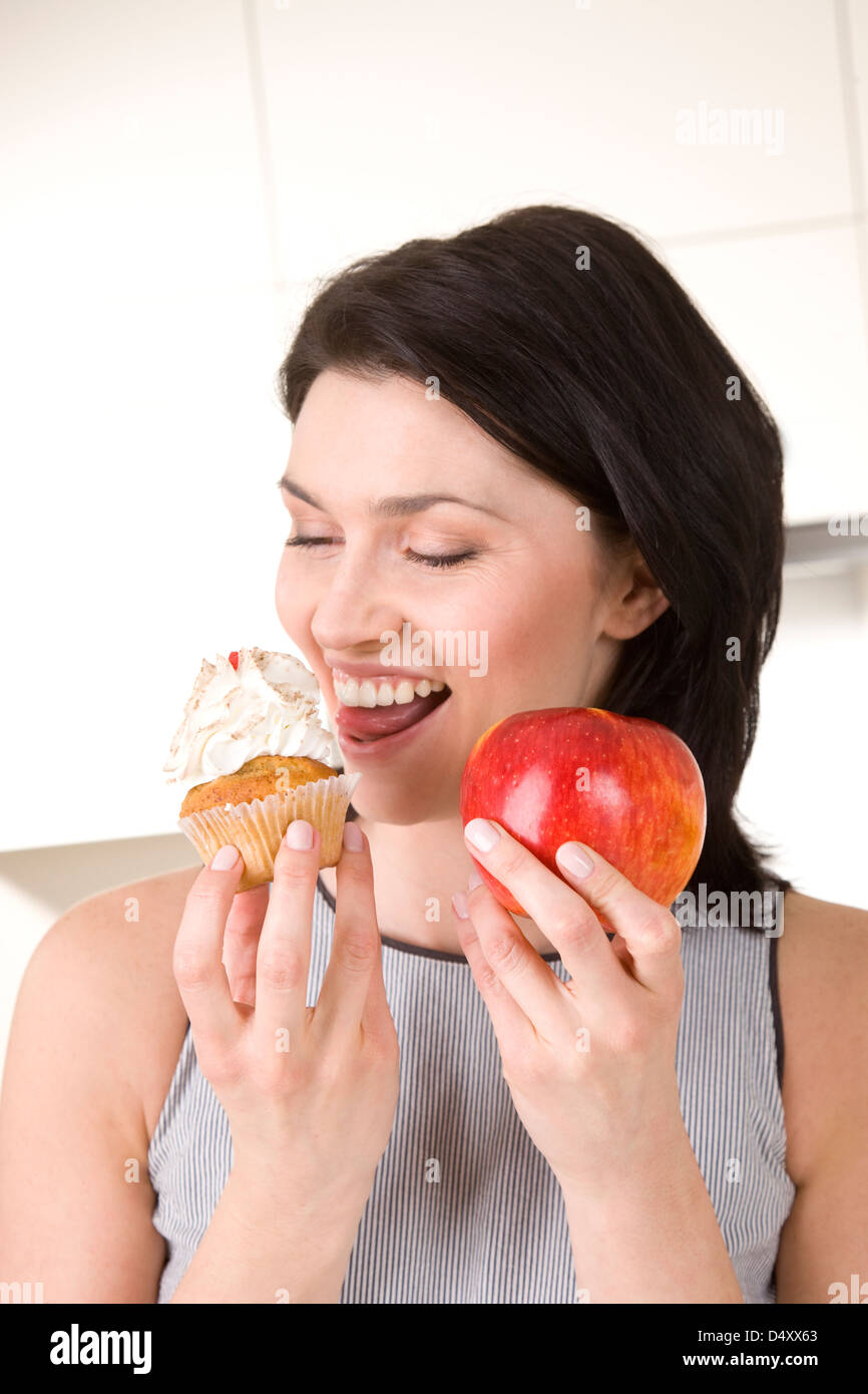 Frau Holding Kuchen und Apfel Stockfoto