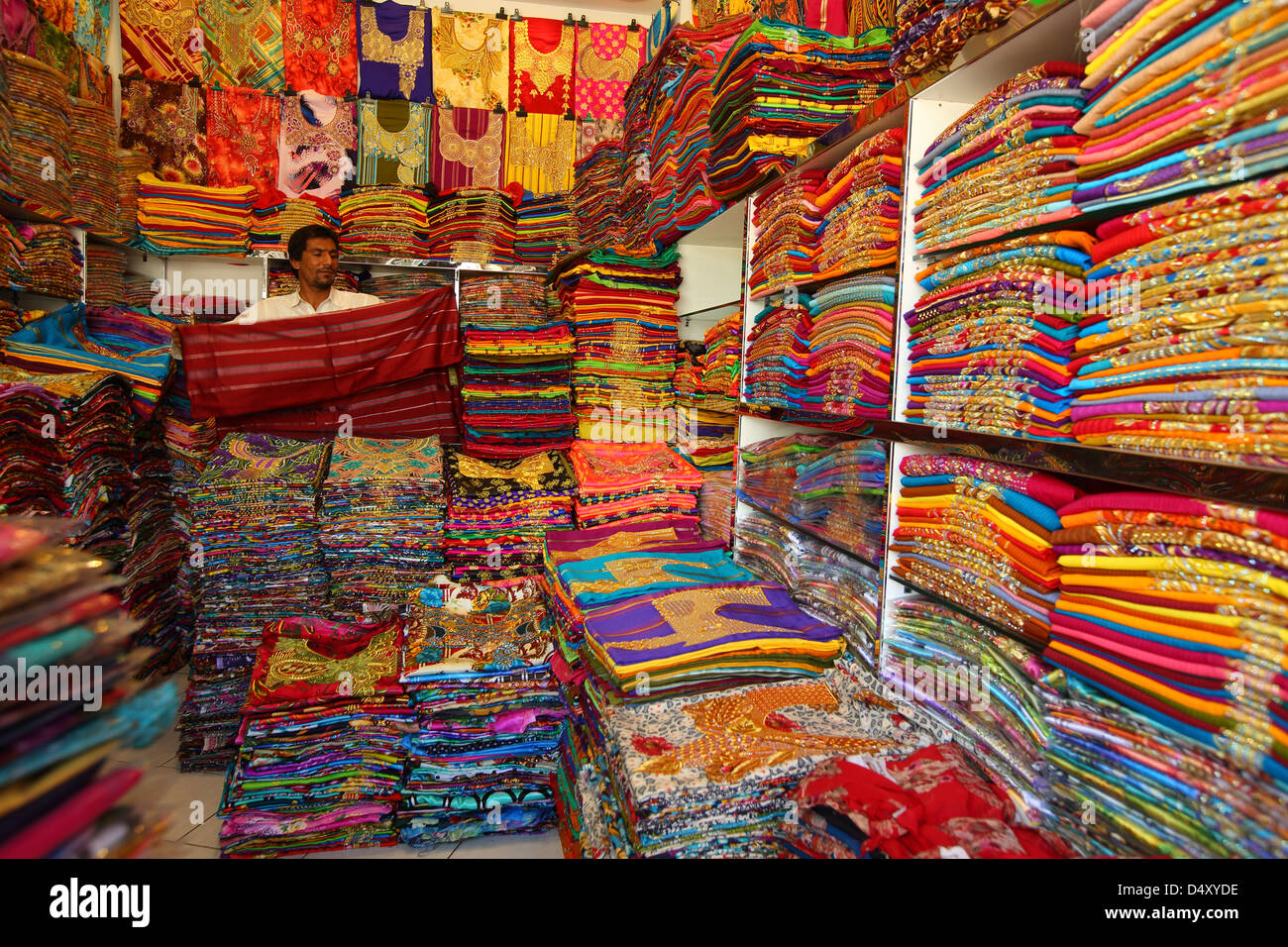 Der Mensch Falten Stoff im Textilgeschäft, Dubai, Vereinigte Arabische Emirate Stockfoto
