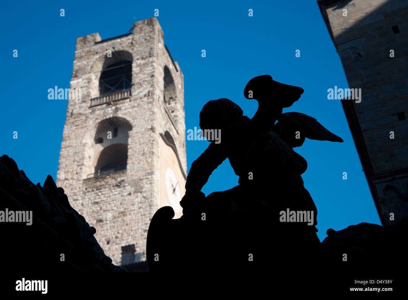 Bergamo - Statue des Engels vom Tor des Baptisterium am Piazza del Duomo und Torre del Comune im Hintergrund Stockfoto