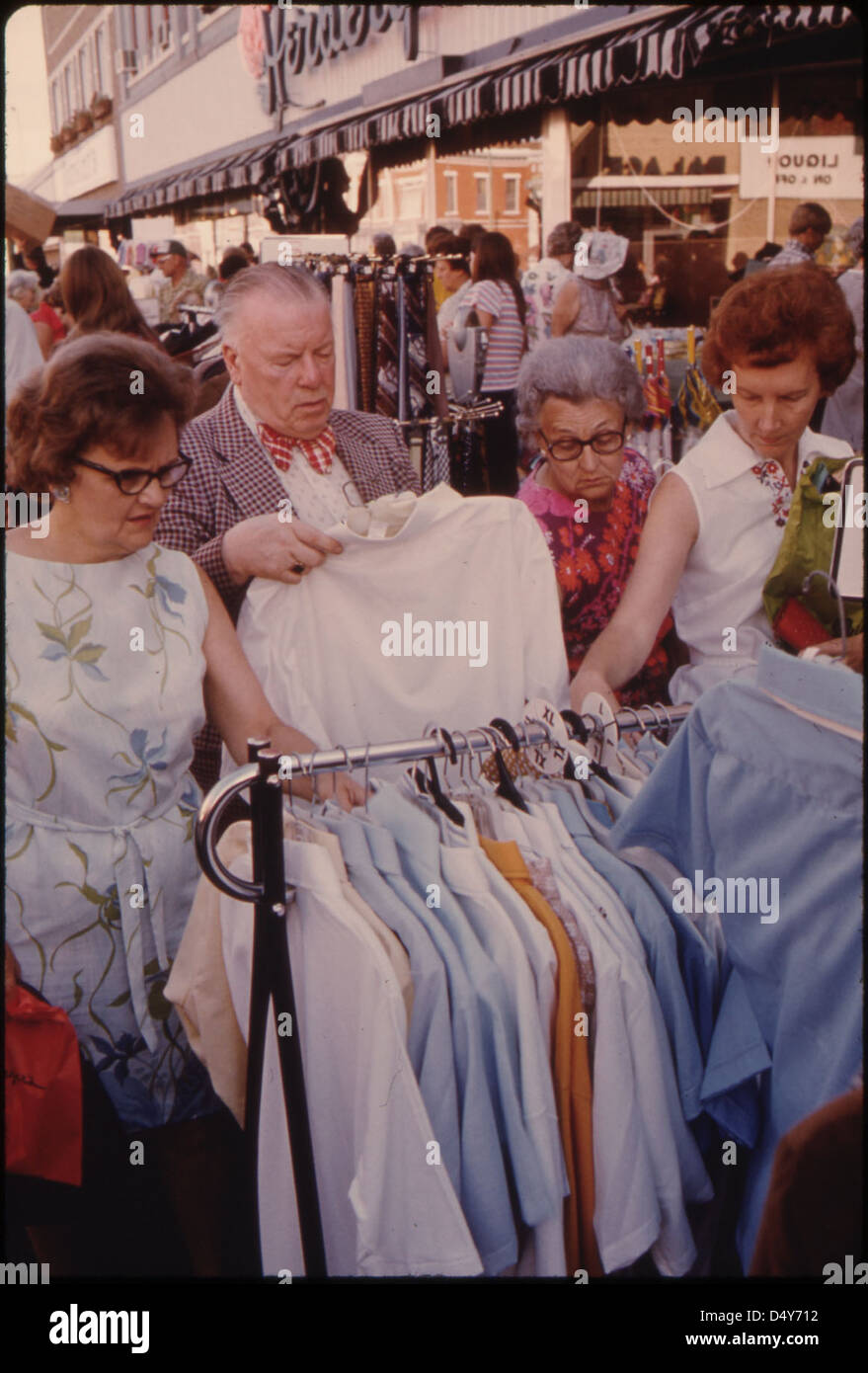 Erwachsene suchen während der jährlichen Summer Crazy Days in New Ulm, Minnesota, nach Schnäppchenartikeln. Der lebhafte Markt der Stadt ist eine zentrale Drehscheibe für die umliegende Bauerngemeinde. Stockfoto