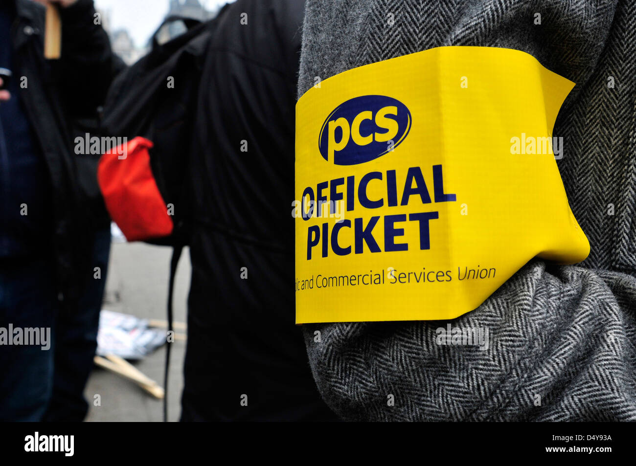 Eine Nahaufnahme der eine gelbe und blaue Armbinde lesen "PCS, offizielle Zaunlatte" bei einer Kundgebung vor dem Parlament am Budget Tag. Stockfoto