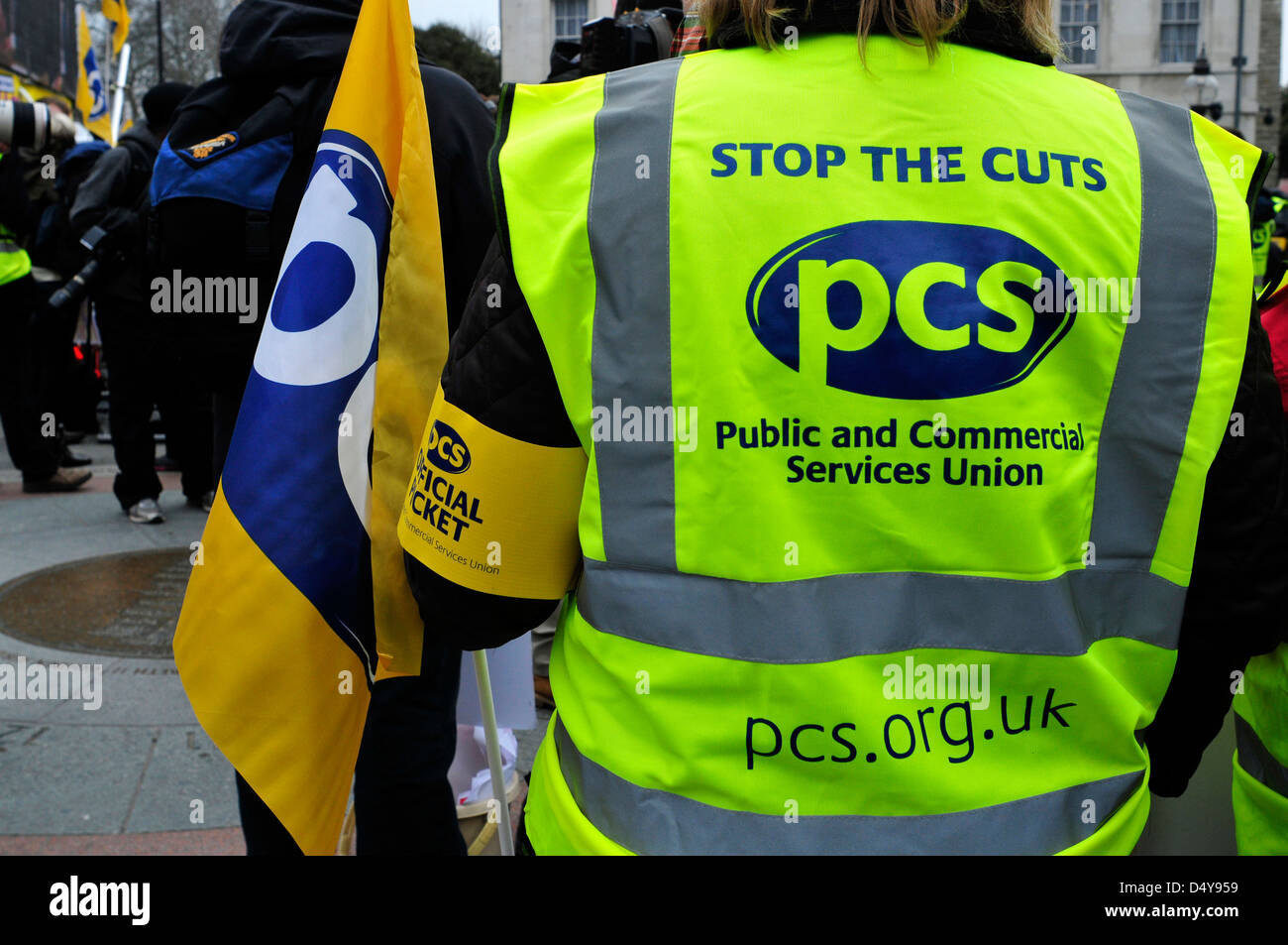 Ein Stürmer tragen eine reflektierende Weste mit Slogans "Stop die Kürzungen", auf einer Kundgebung vor dem Parlament am Budget Tag. London. Stockfoto