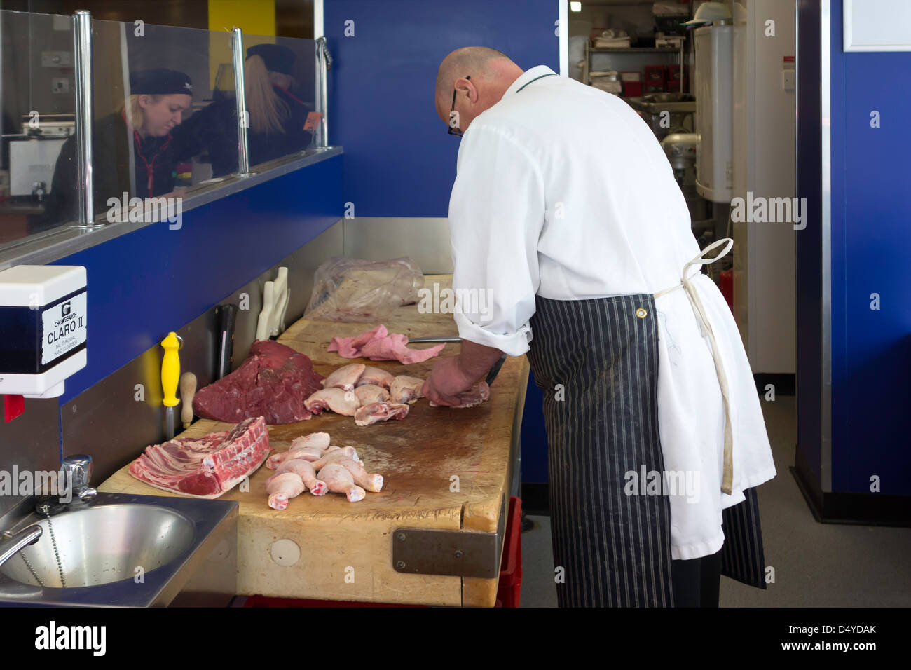 Ein Metzger in seiner Werkstatt Filetieren Huhn für einen Kunden Stockfoto