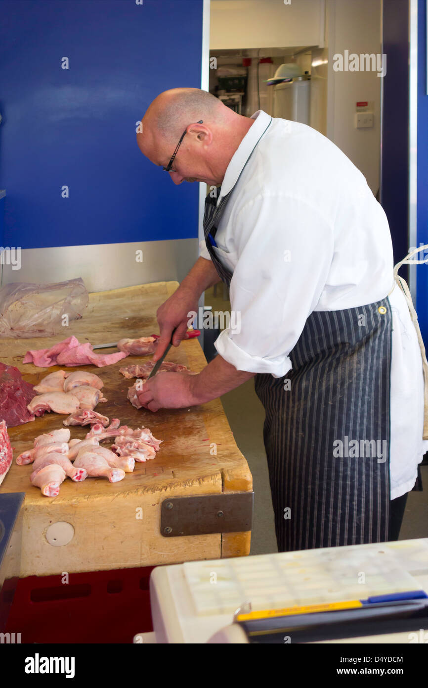 Ein Metzger in seiner Werkstatt Filetieren Huhn für einen Kunden Stockfoto