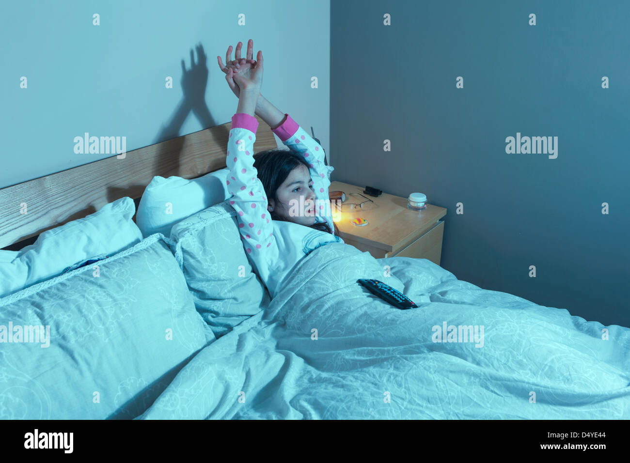 Junges Mädchen schaut TV im Bett Stockfoto