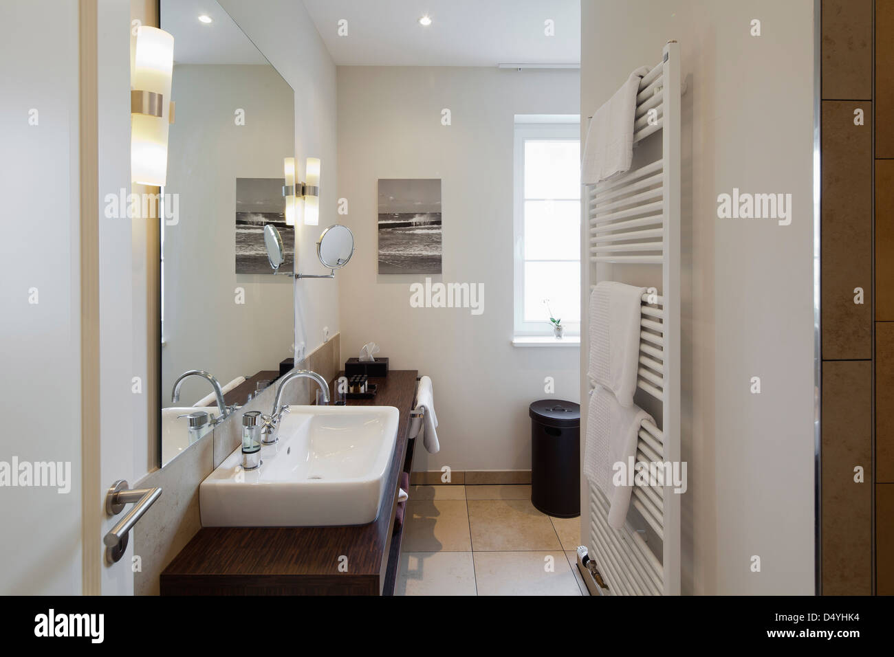 Handtuchwärmer und Waschbecken im modernen Badezimmer Stockfoto