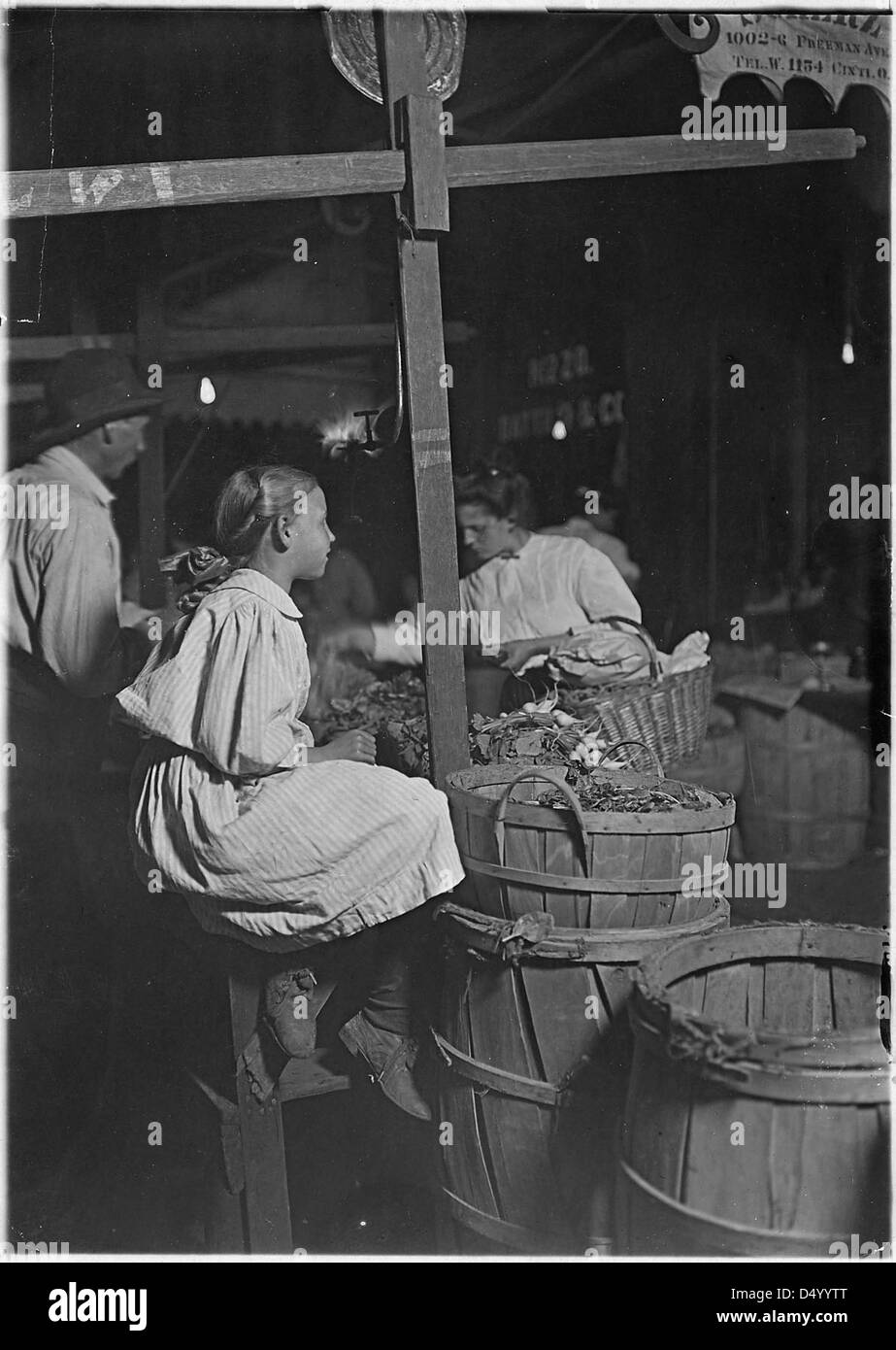 Ein Foto vom August 1908, auf dem Jungen und Mädchen Radieschen für einen Cent pro Haufen verkaufen. Dieses Bild, aufgenommen von Lewis Hine, dokumentiert Kinderarbeit im Amerika des frühen 20. Jahrhunderts. Stockfoto