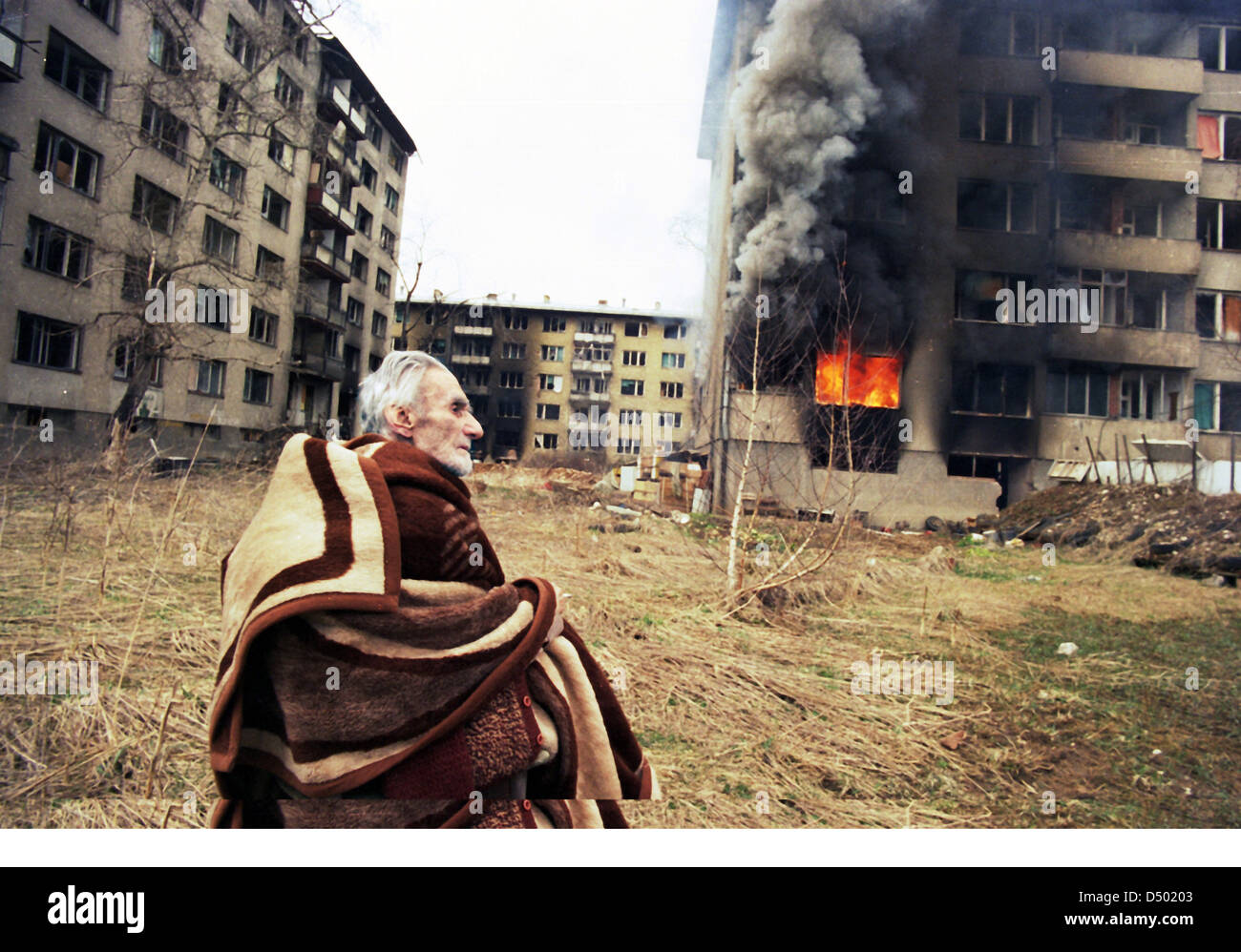 Ein ethnische kroatische Mann betet außerhalb seiner brennenden Wohnung am letzten Tag der serbischen Belagerung in Sarajevo, Bosnien, auf Montag, 18. März 1996. Stockfoto
