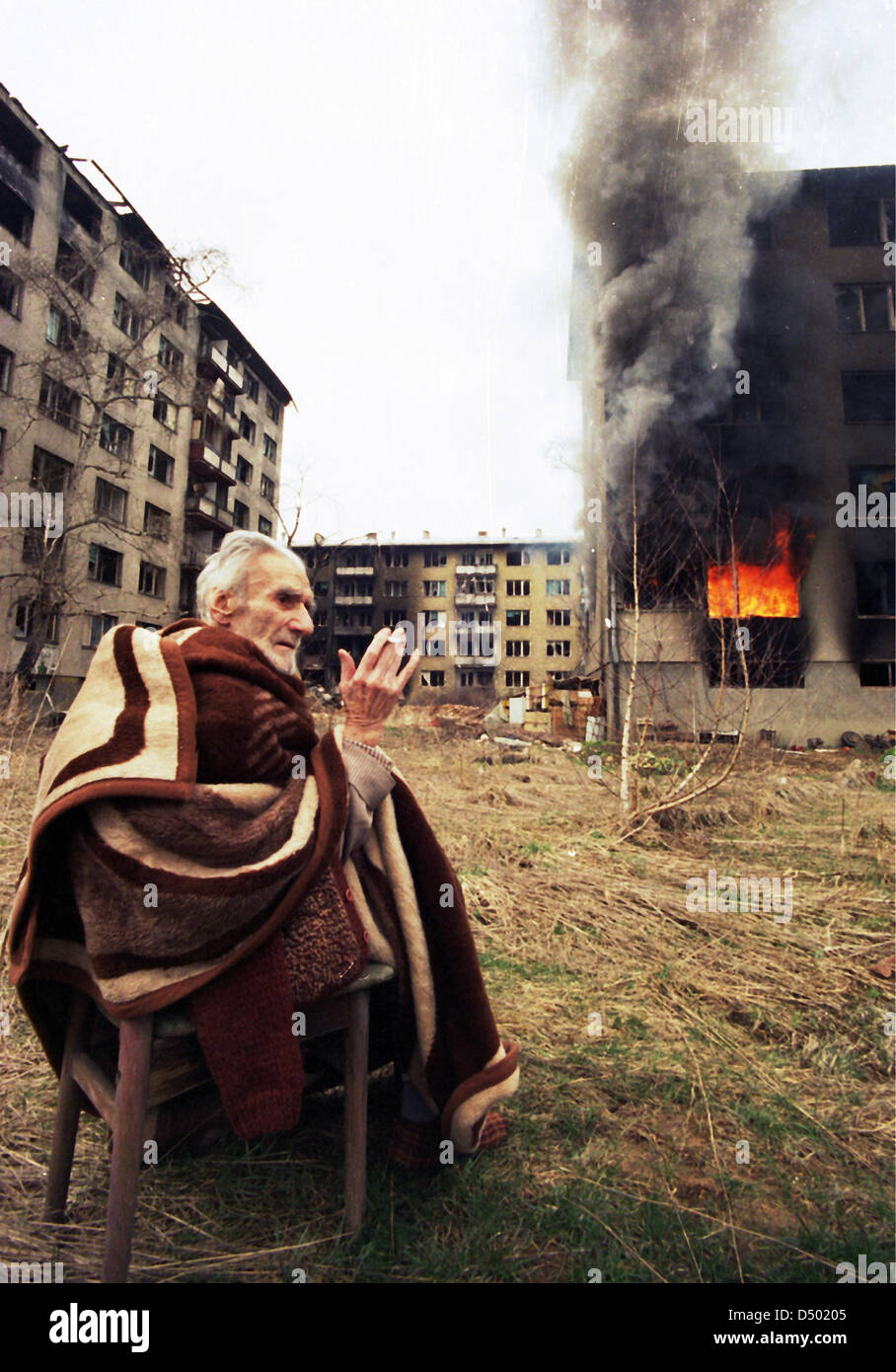Ein ethnische kroatische Mann betet außerhalb seiner brennenden Wohnung am letzten Tag der serbischen Belagerung in Sarajevo, Bosnien, auf Montag, 18. März 1996. Stockfoto
