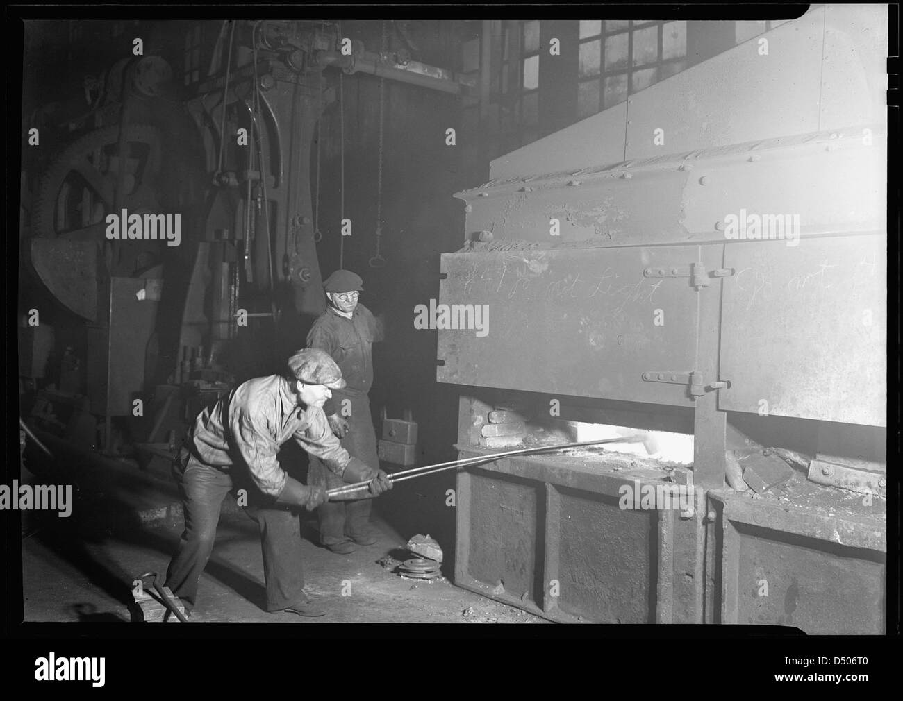 Eisenbahnteile. Baldwin Lokomotivarbeiten. Ein moderner Schmiedeofen (oder Schmiede) im [sic] schmiedegeschäft. Schmied und Helfer, 1936 Stockfoto