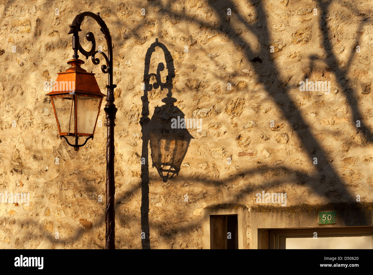 Reich verzierte Lampe Gießen Schatten an Wand in Villennes-Sur-Seine, Yvelines, Frankreich Stockfoto