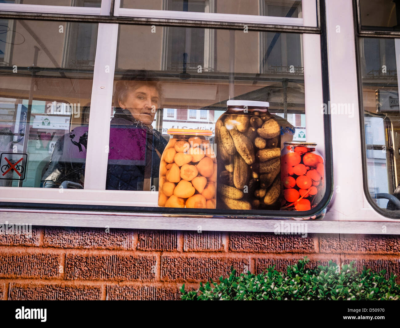 Frau sitzt in einer Straßenbahn mit einigen Anzeigen unter windows Stockfoto